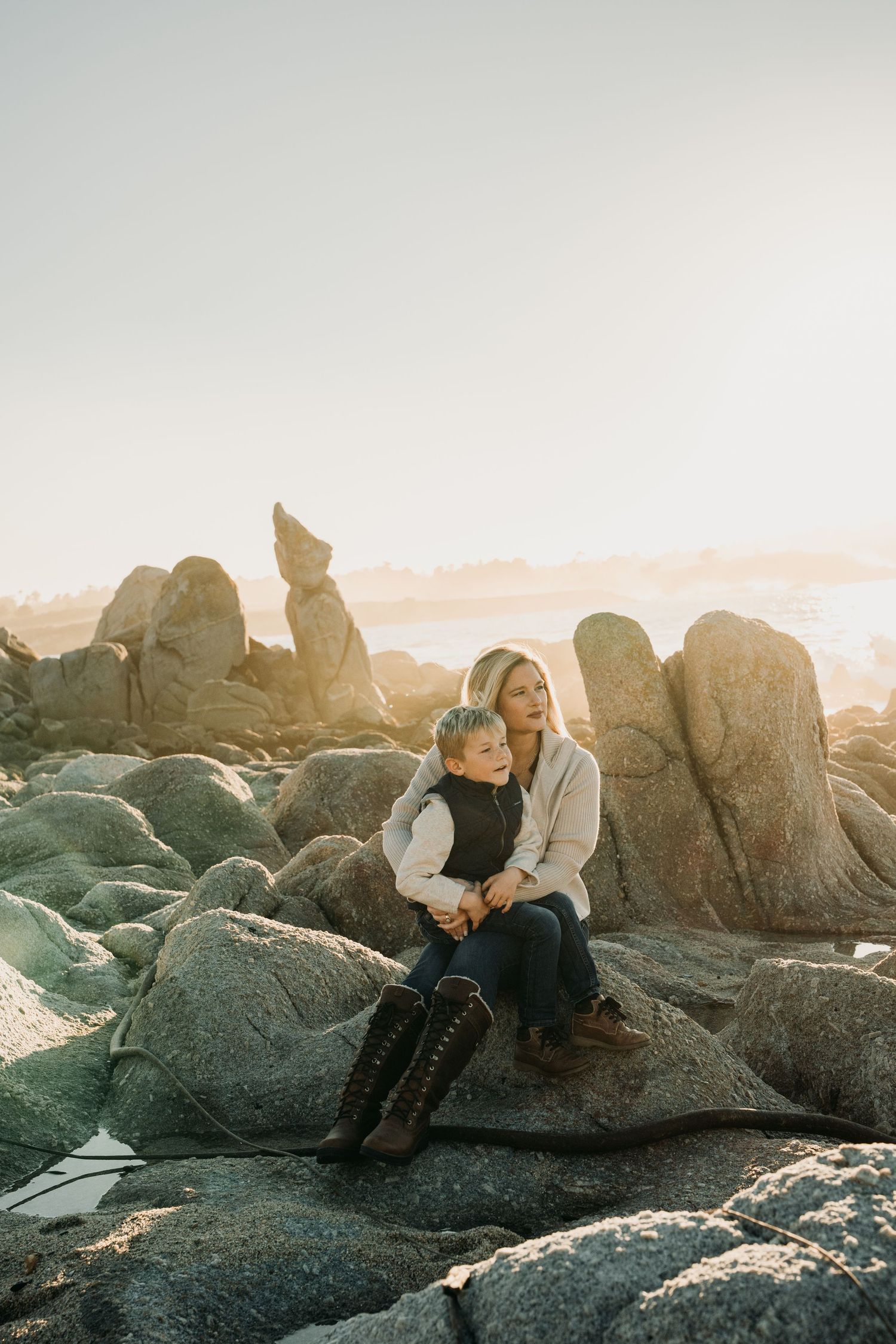 A mom holding her baby boy at Carmel-by-the-sea beaches.