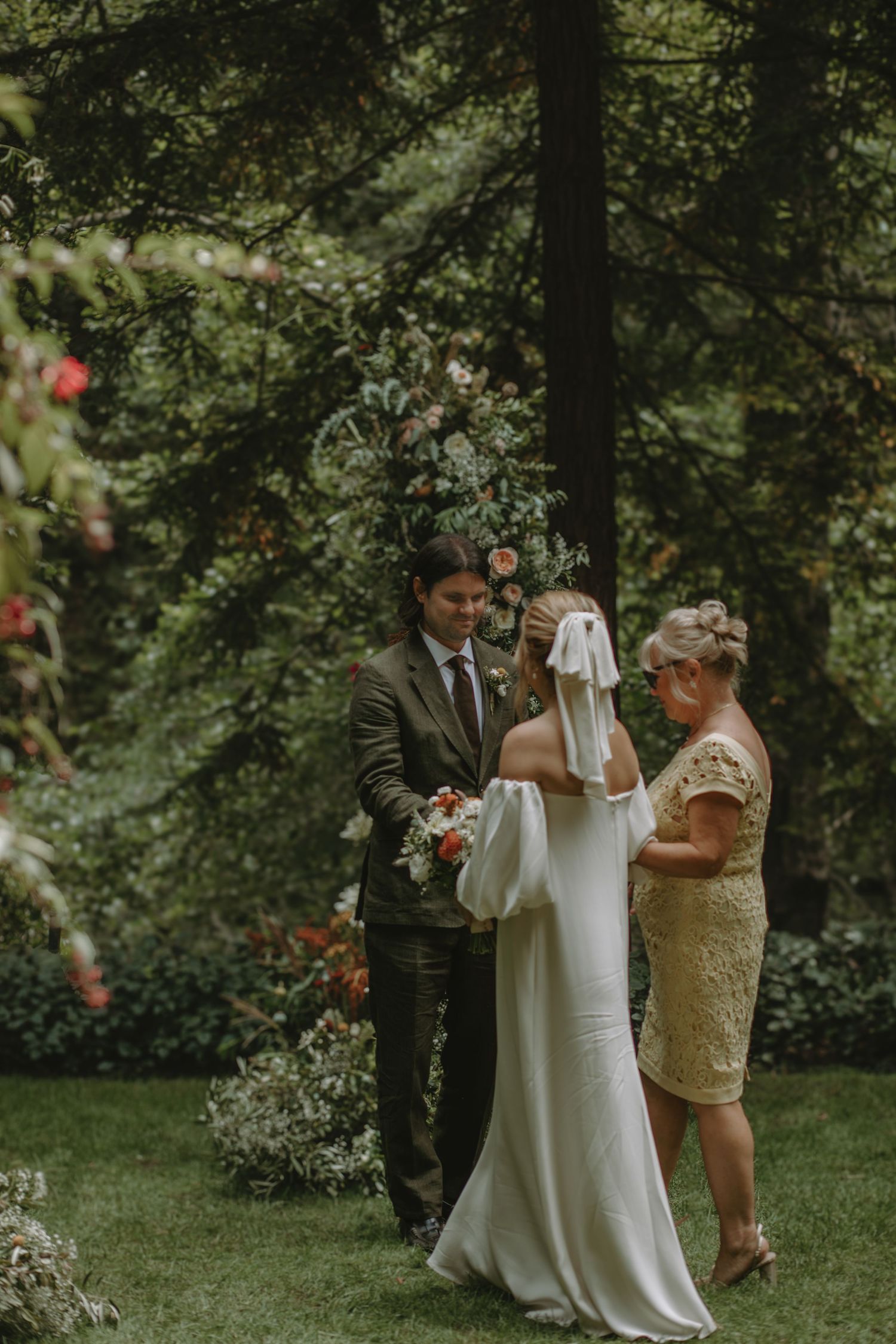 Intimate outdoor wedding ceremony in a lush garden setting with delicate floral arrangements adorning the space.