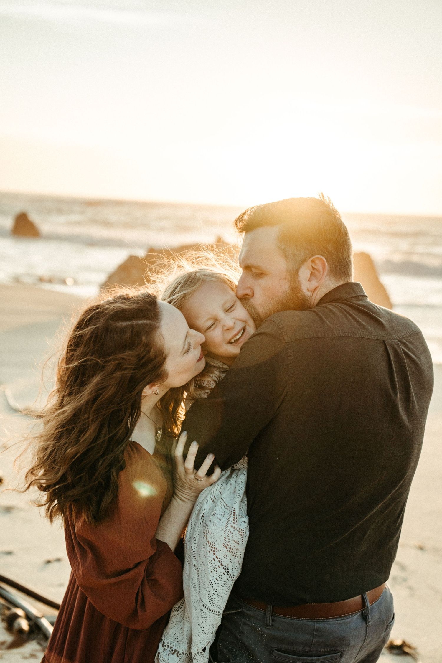 A couple shares intimate moments at sunset on the beach in a series of romantic photographs.