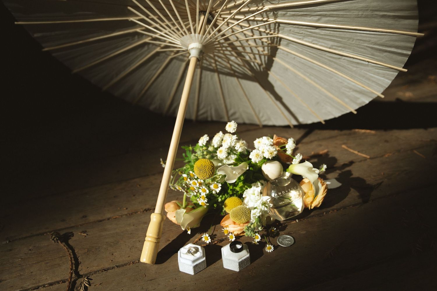A row of elegant white paper parasols decorated with delicate floral arrangements creates a romantic wedding backdrop.