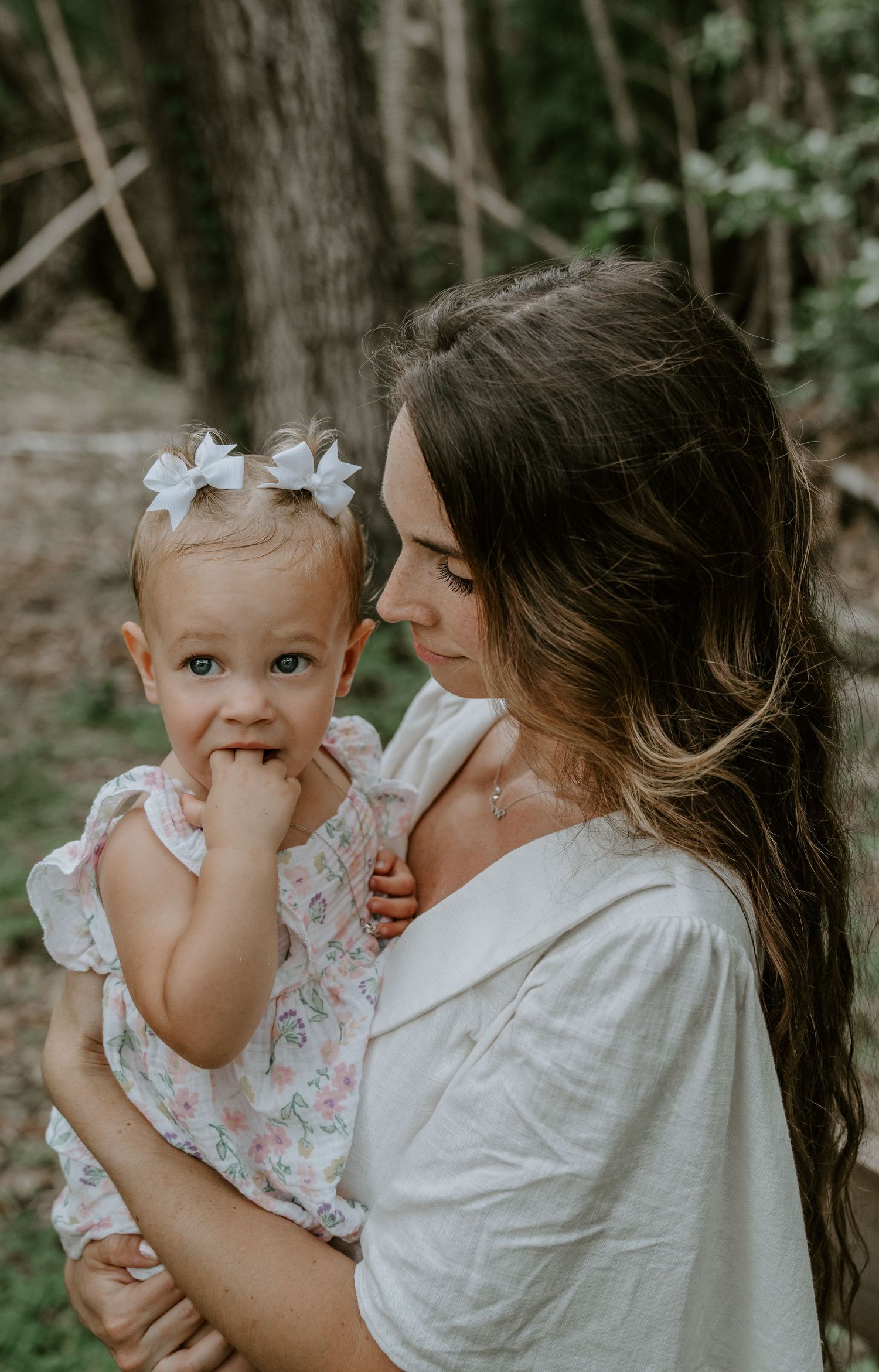 Mother and baby sharing an intimate moment outdoors in natural setting.