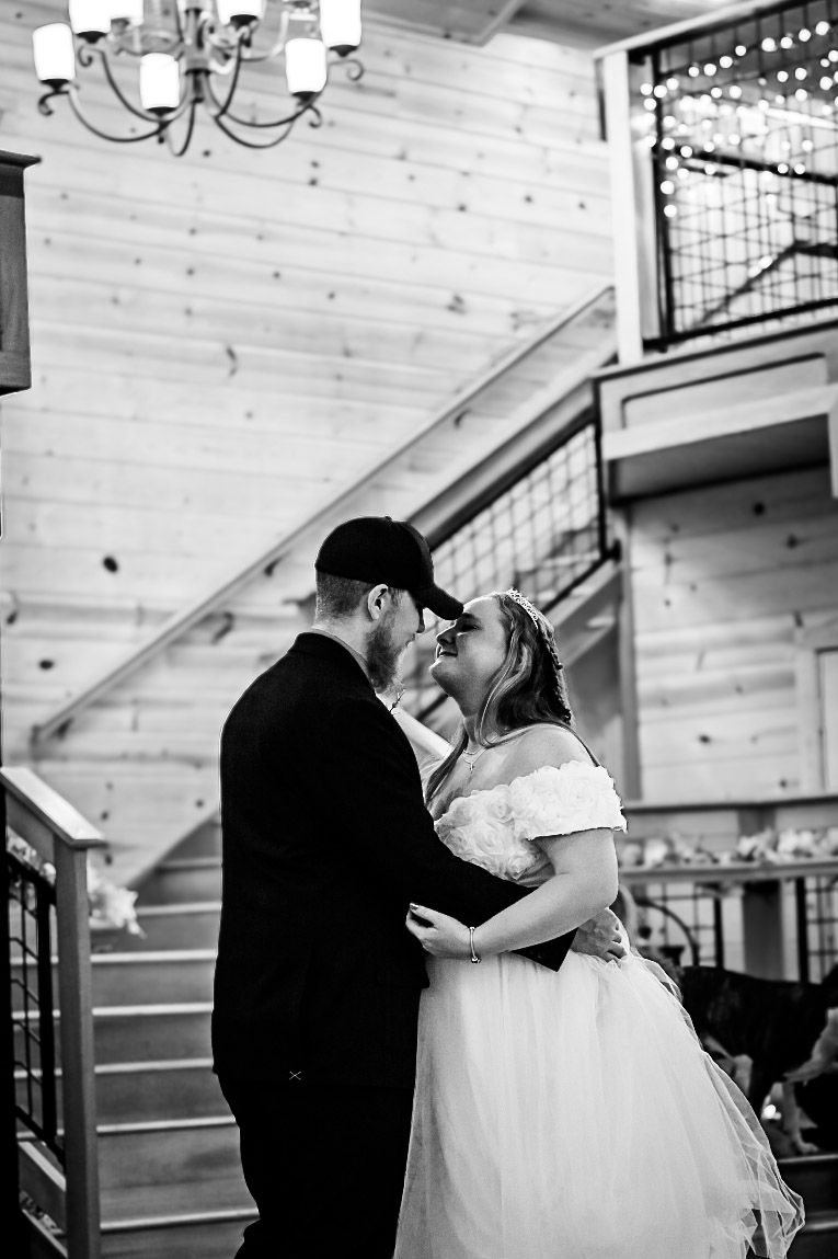 Bride and groom dance their first dance as husband and wife. Image is in black and white