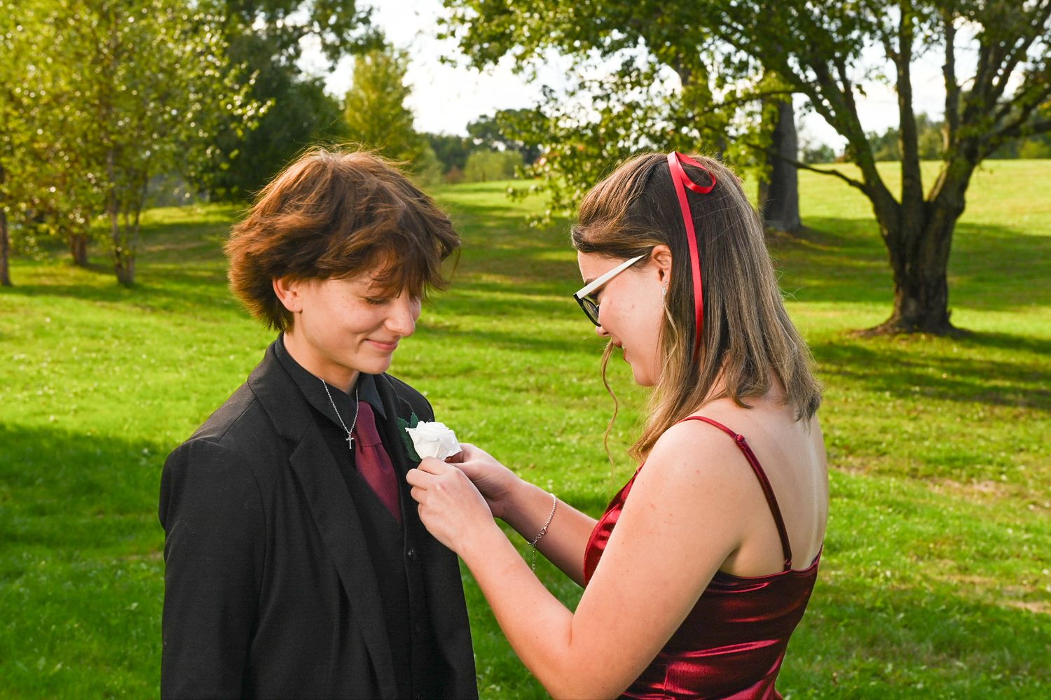 Teen girl pins boutonniere on homecoming date