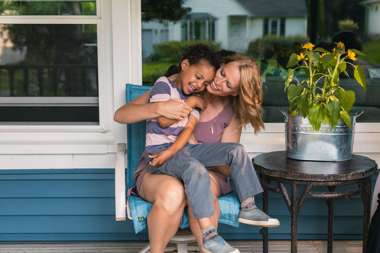 madison wi family photographer lifestyle at home photos mom hugging young son laughing unposed candid moment porch summer floral portfolio