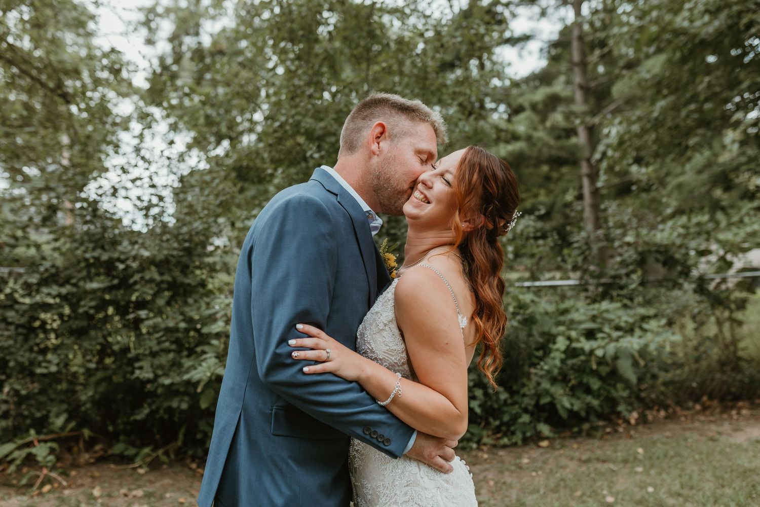 Romantic outdoor wedding portraits captured in a lush green garden setting.
