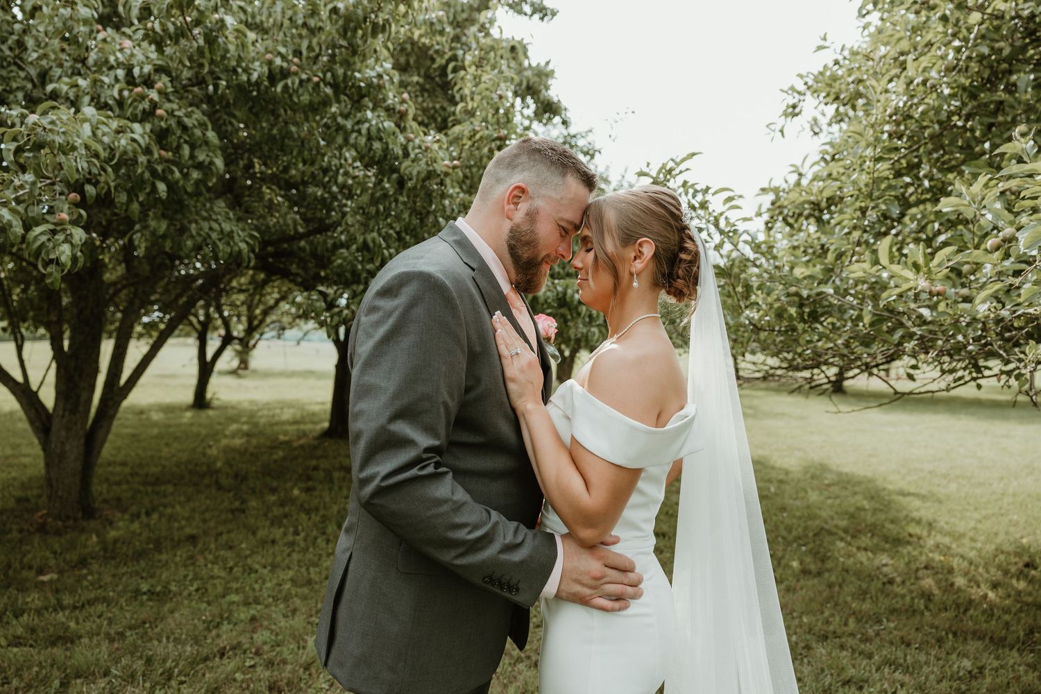 Romantic outdoor wedding portraits with couples embracing in a natural garden setting.