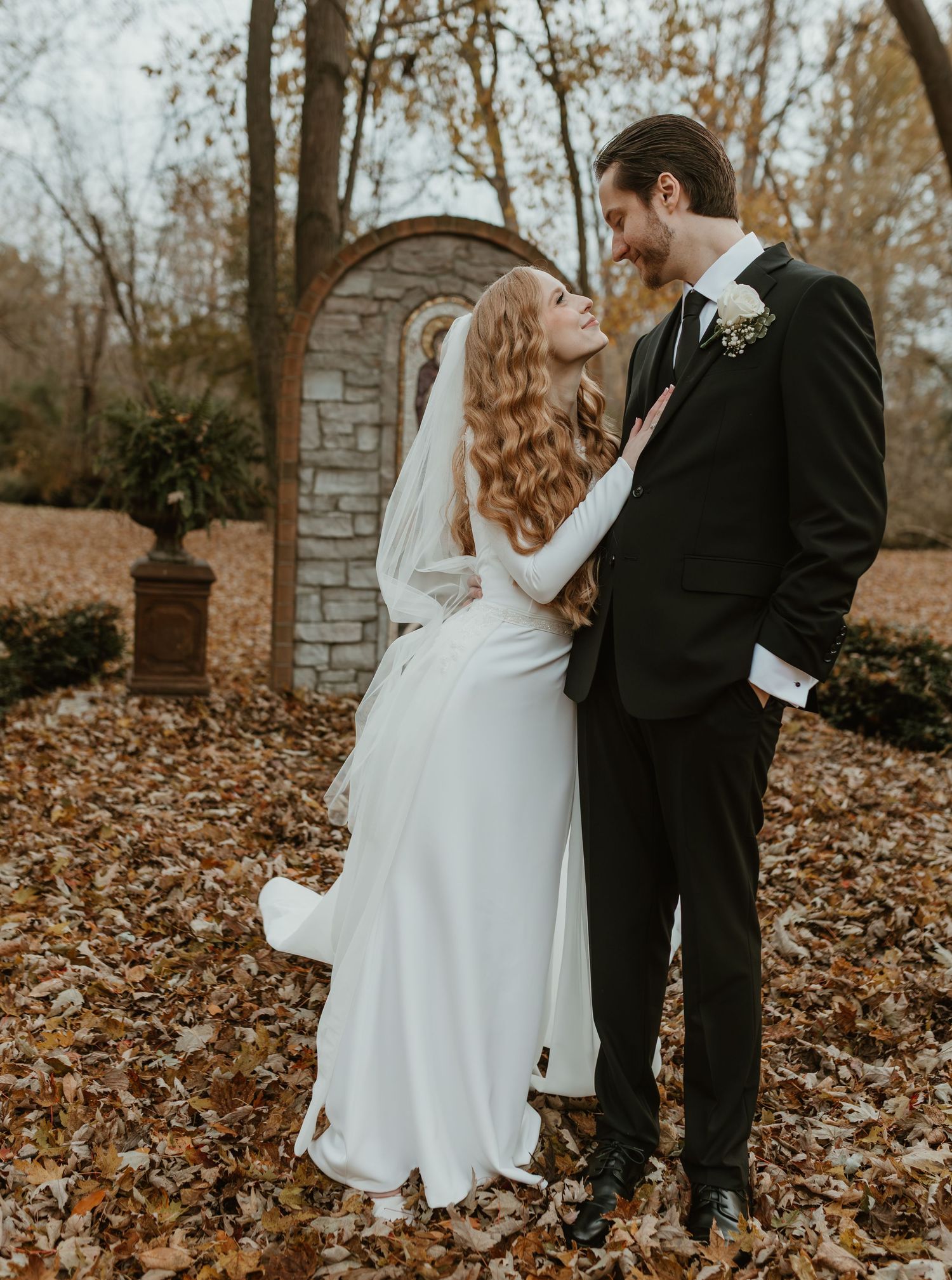 Romantic autumn wedding photos among fallen leaves and stone walls.
