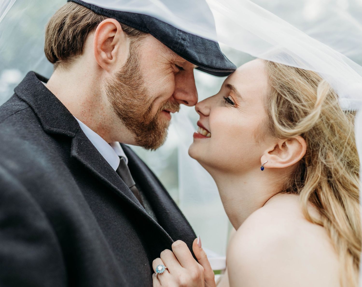 A romantic couple shares intimate moments while sitting on white steps in formal wedding attire.