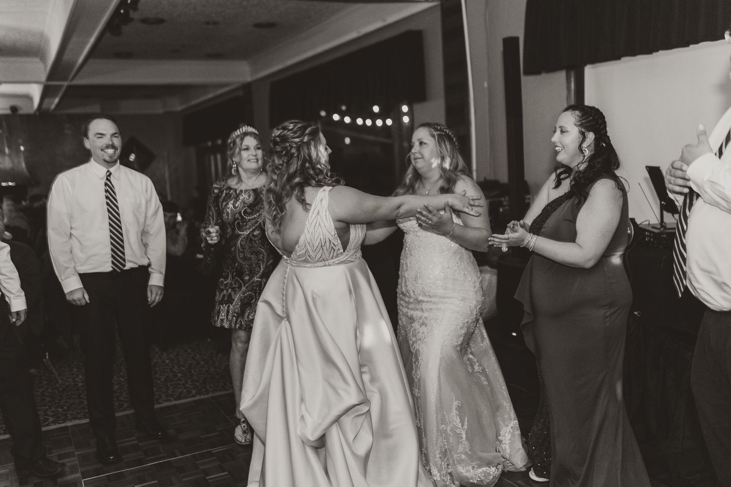 Wedding guests dancing and celebrating together on a dance floor at a reception.