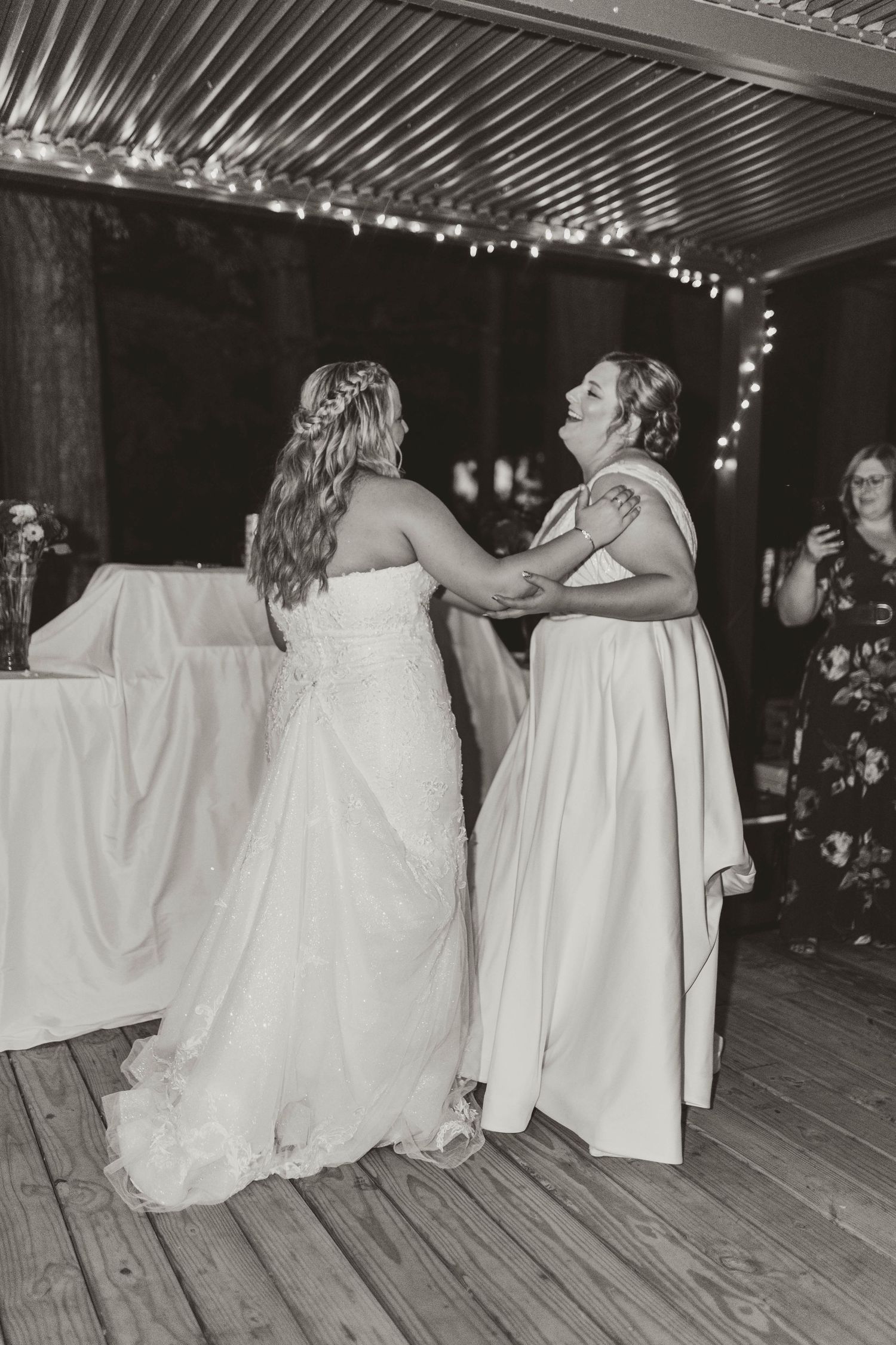 Black and white sequence of couples dancing on a wooden deck under string lights.
