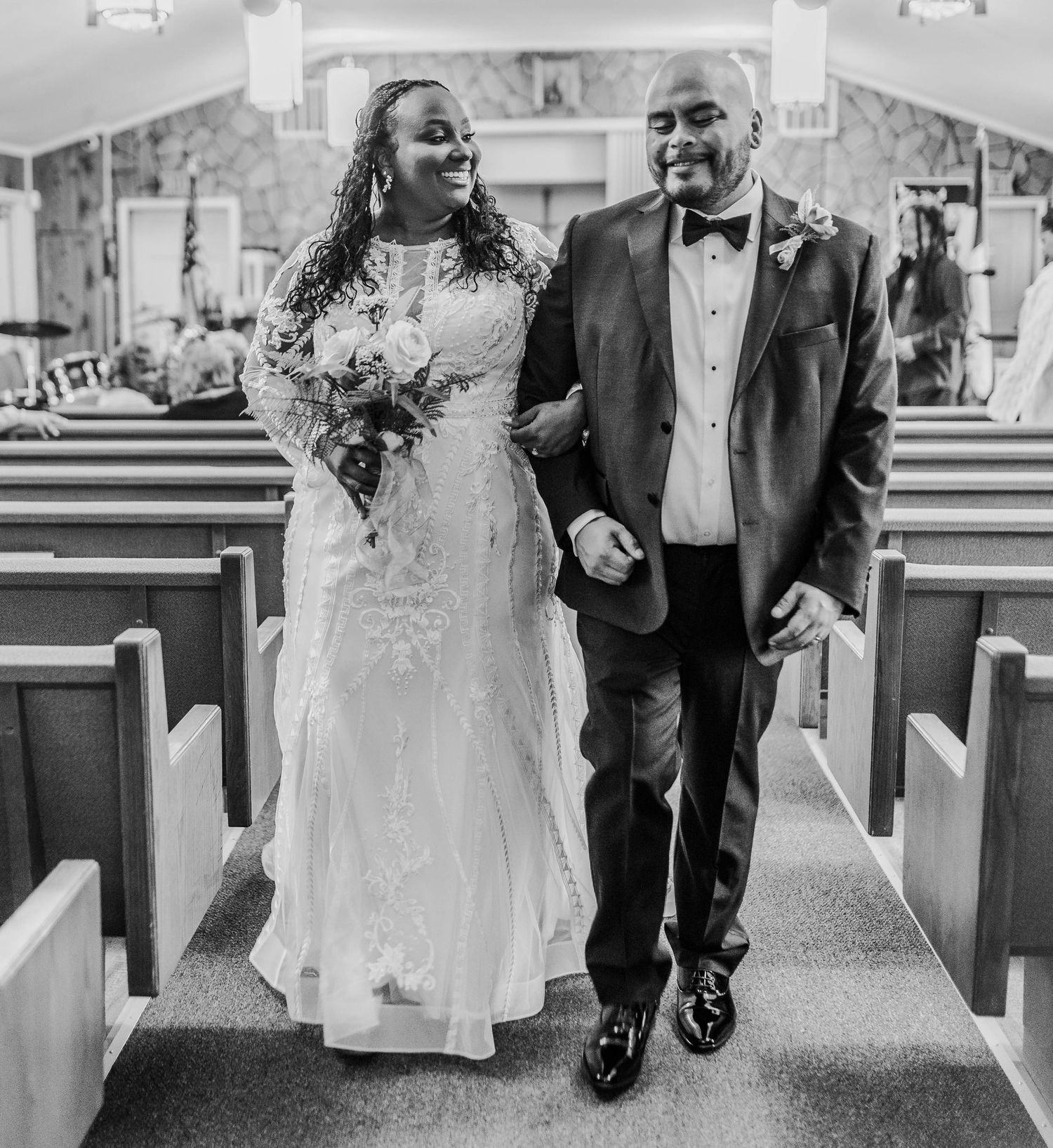 A happy couple walking down the church aisle after their wedding ceremony.