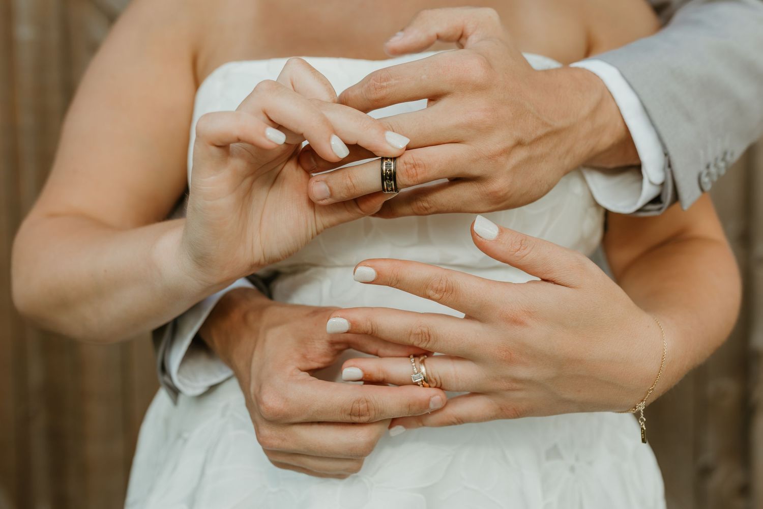 Close-up of hands with wedding rings during intimate ceremony moment.