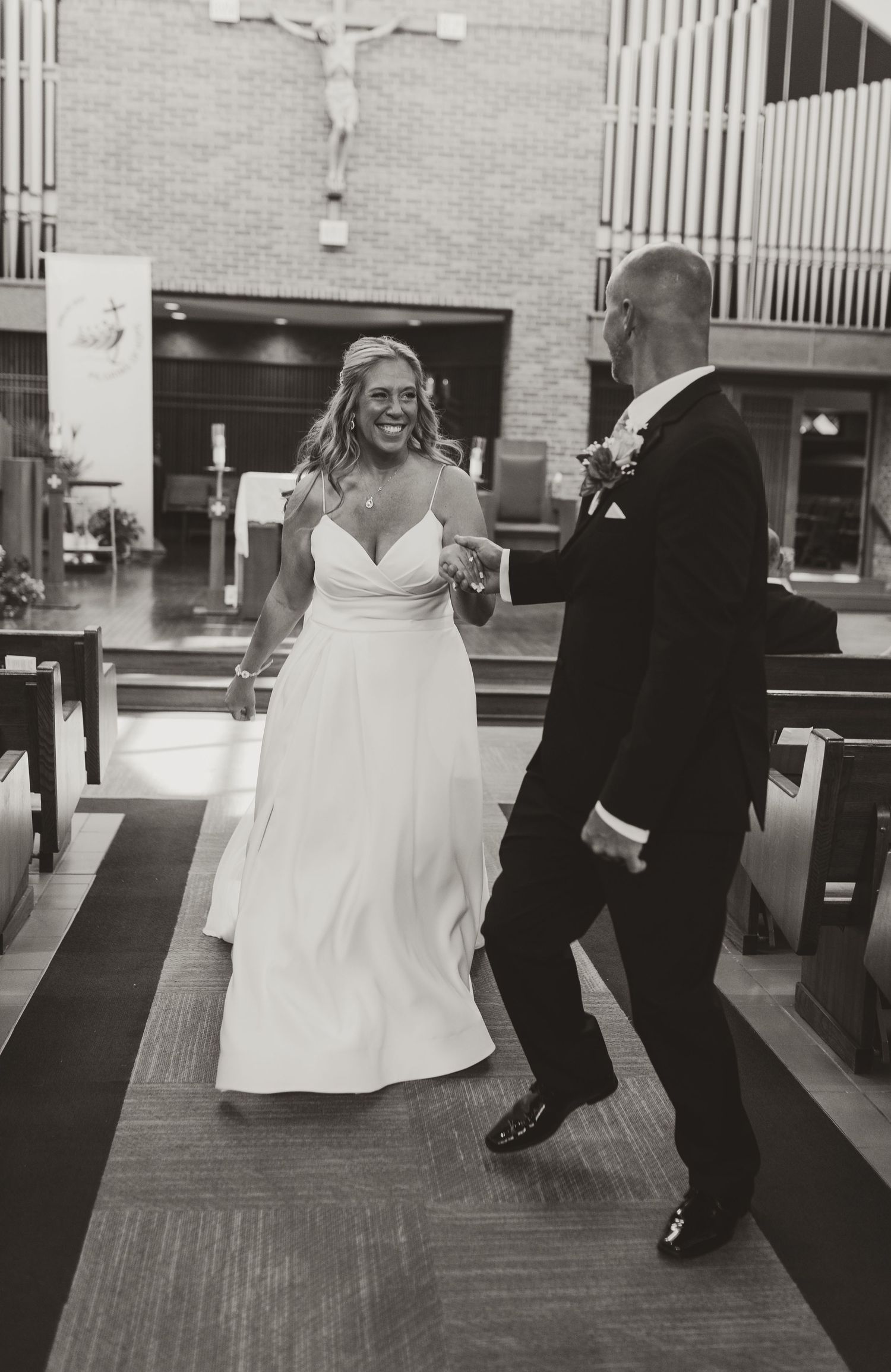 Black and white wedding dance sequence showing playful movement across a wooden floor.