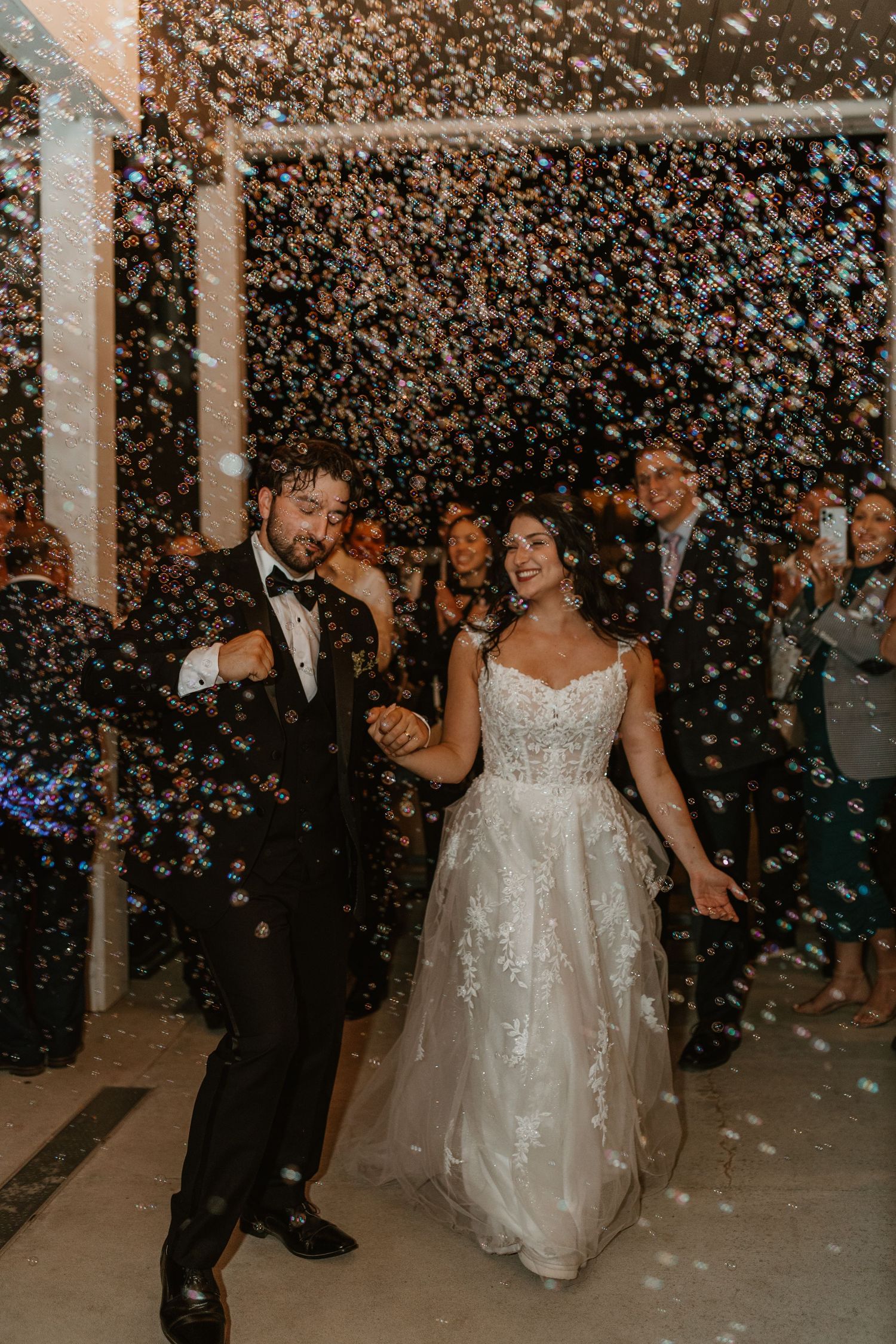 Wedding celebration with confetti falling as couple dances in an indoor venue.
