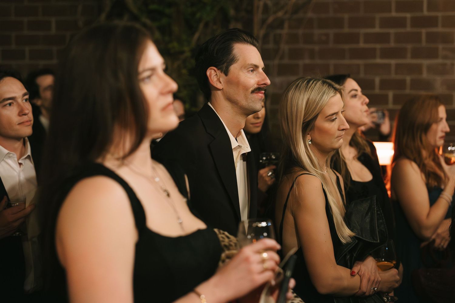 Wedding guests in formal attire enjoying an evening celebration.
