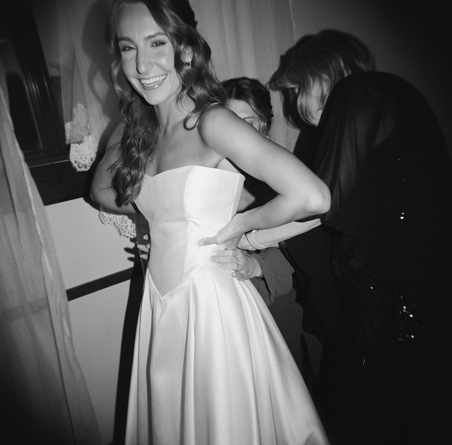 A series of black and white photos showing someone in a white dress posing and dancing in an indoor setting.