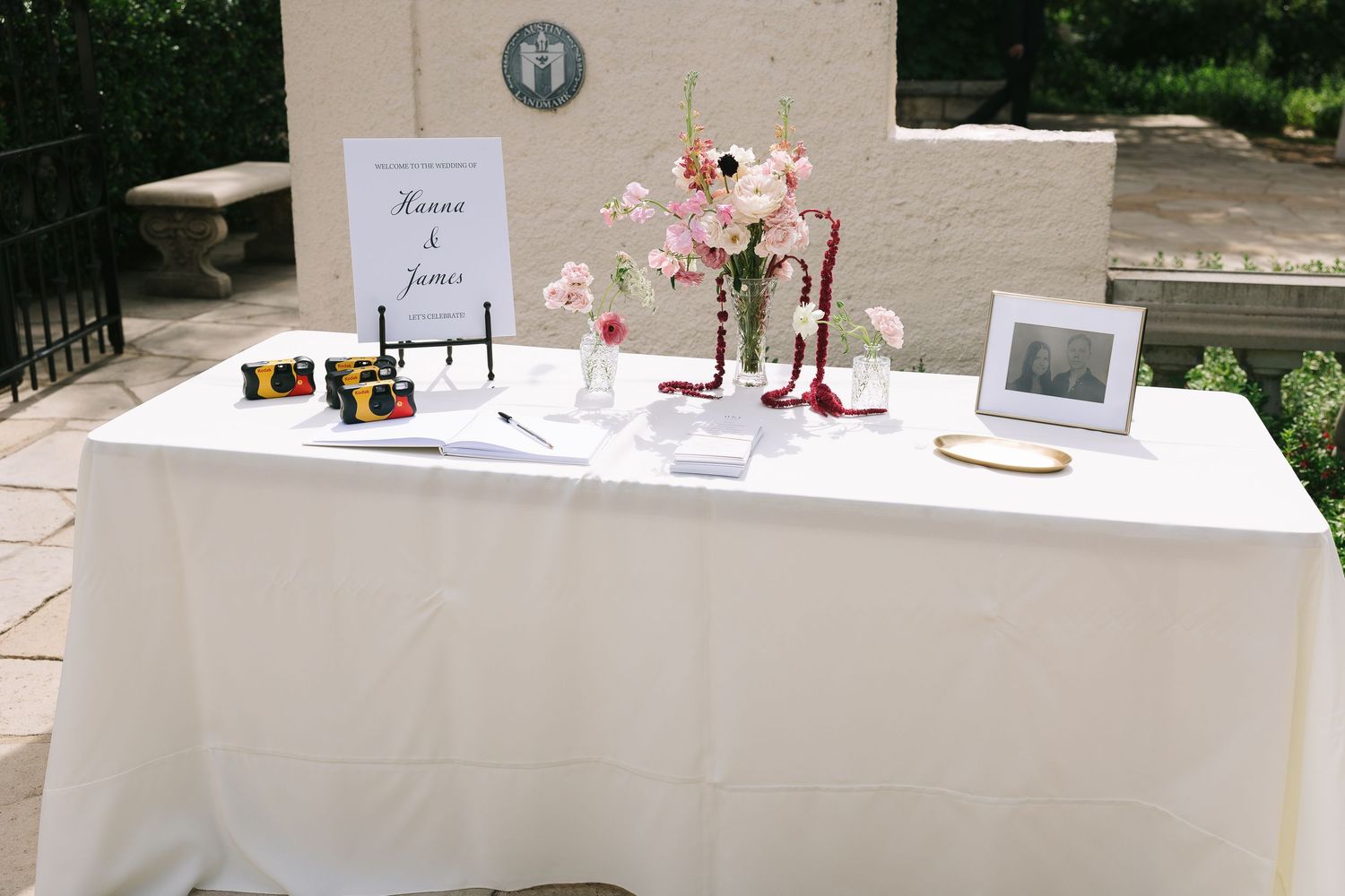 Wedding guest book table with white tablecloth and pink floral decorations.