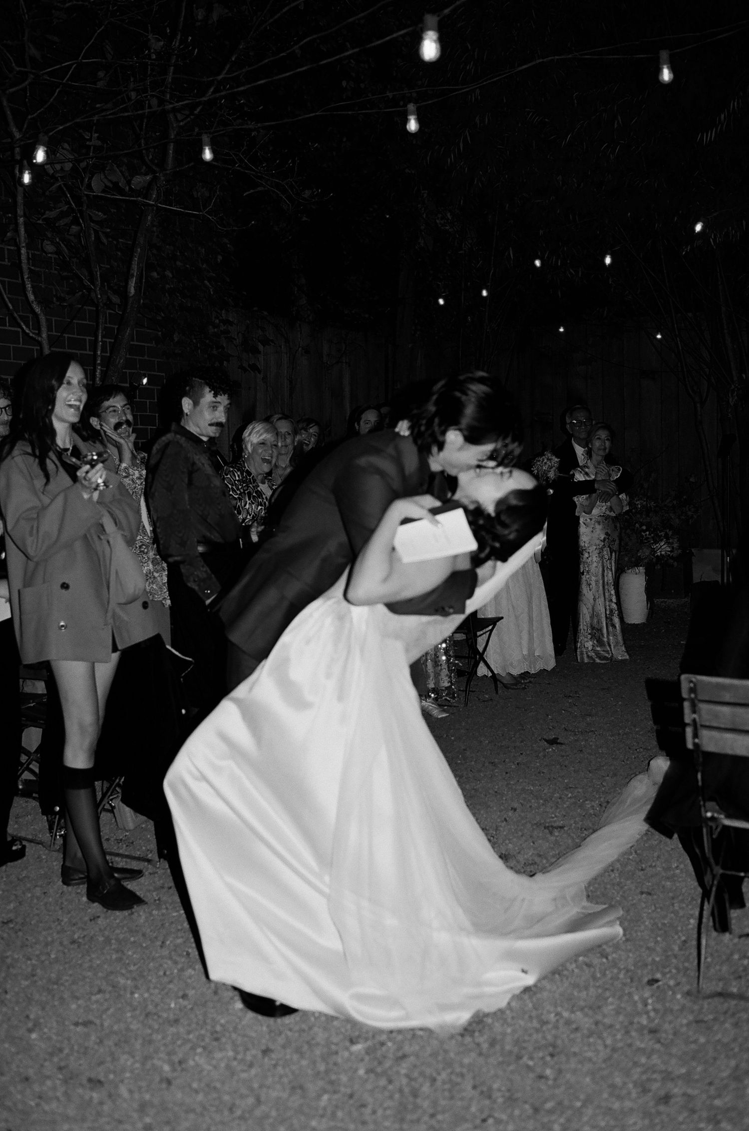 A series of black and white photos showing a couple dancing at a wedding reception with the bride's dress flowing.