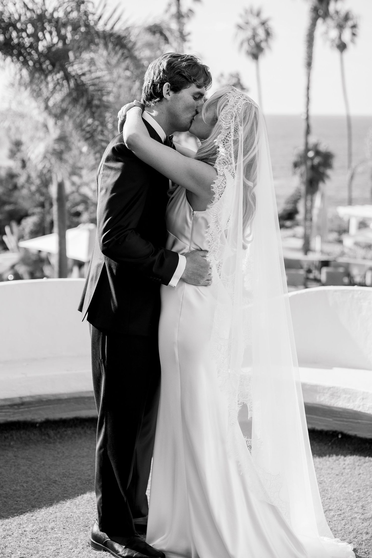 Black and white photo of tender moment between wedding couple during outdoor ceremony.