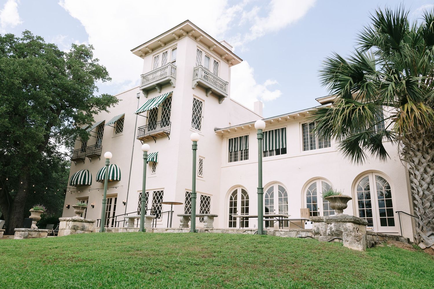 Architectural shots of a grand white building with arched windows and palm trees.
