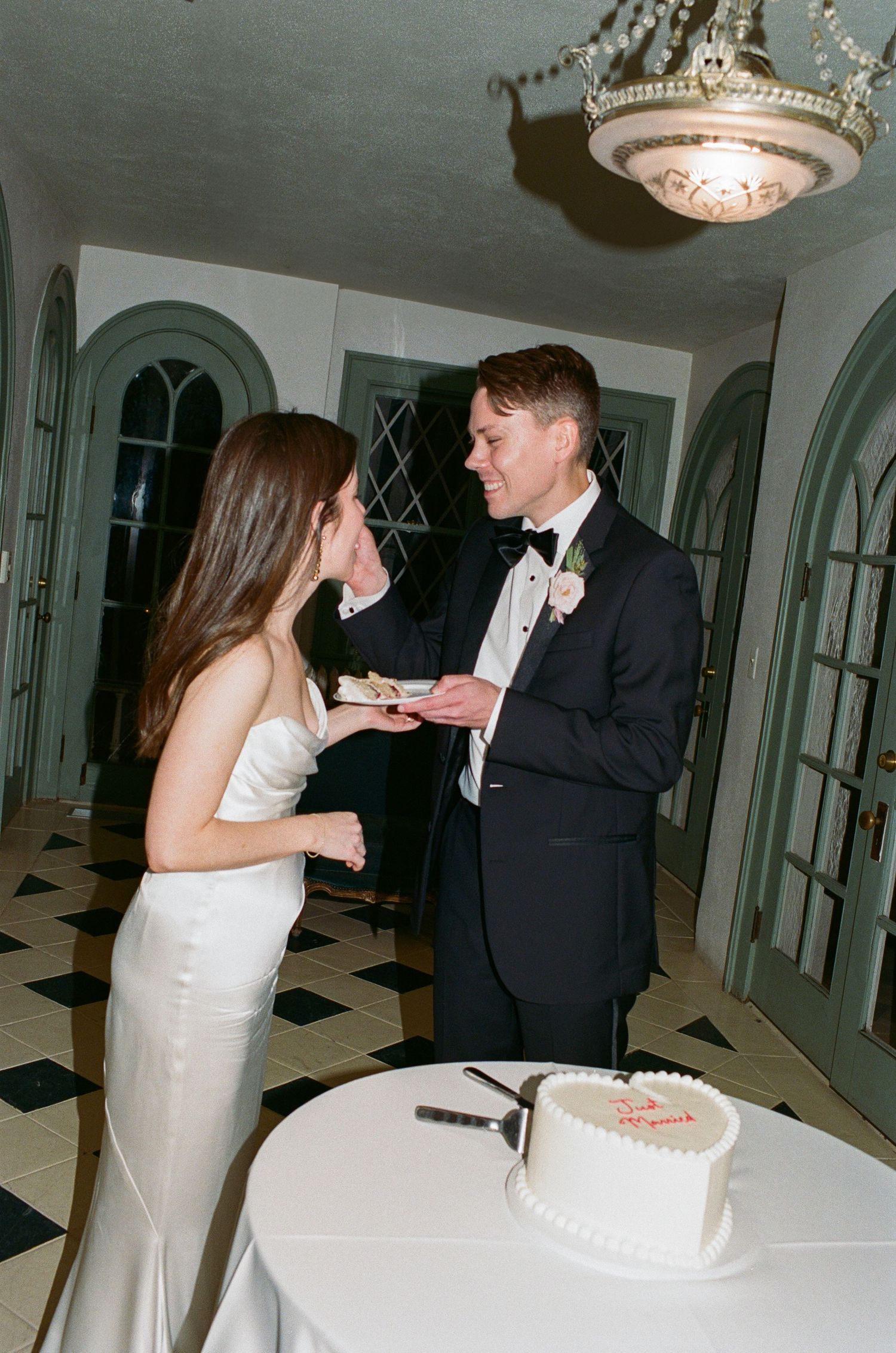 A couple feeding each other wedding cake during their reception celebration.