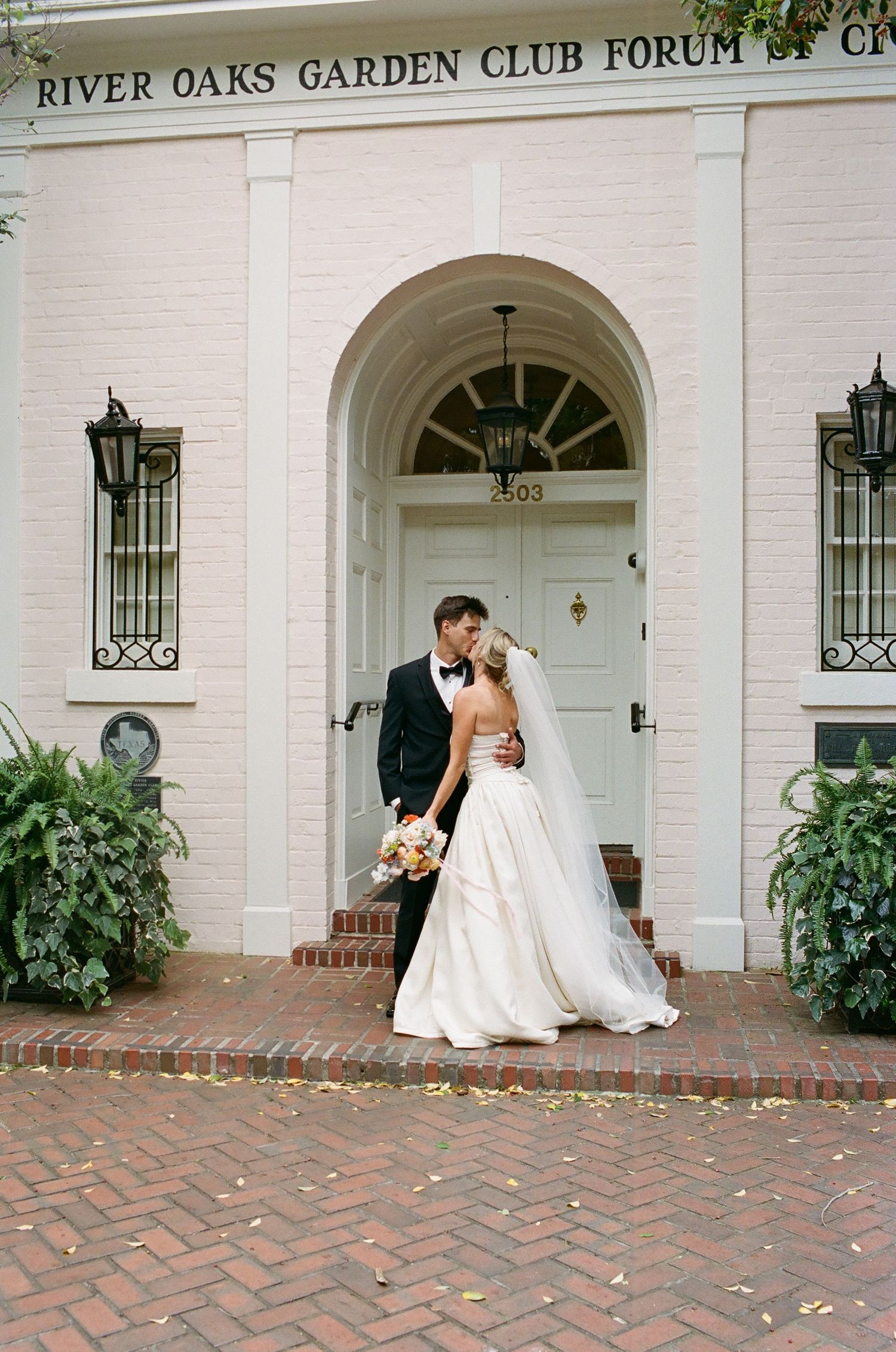 A couple poses outside the River Oaks Garden Club Forum building entrance.