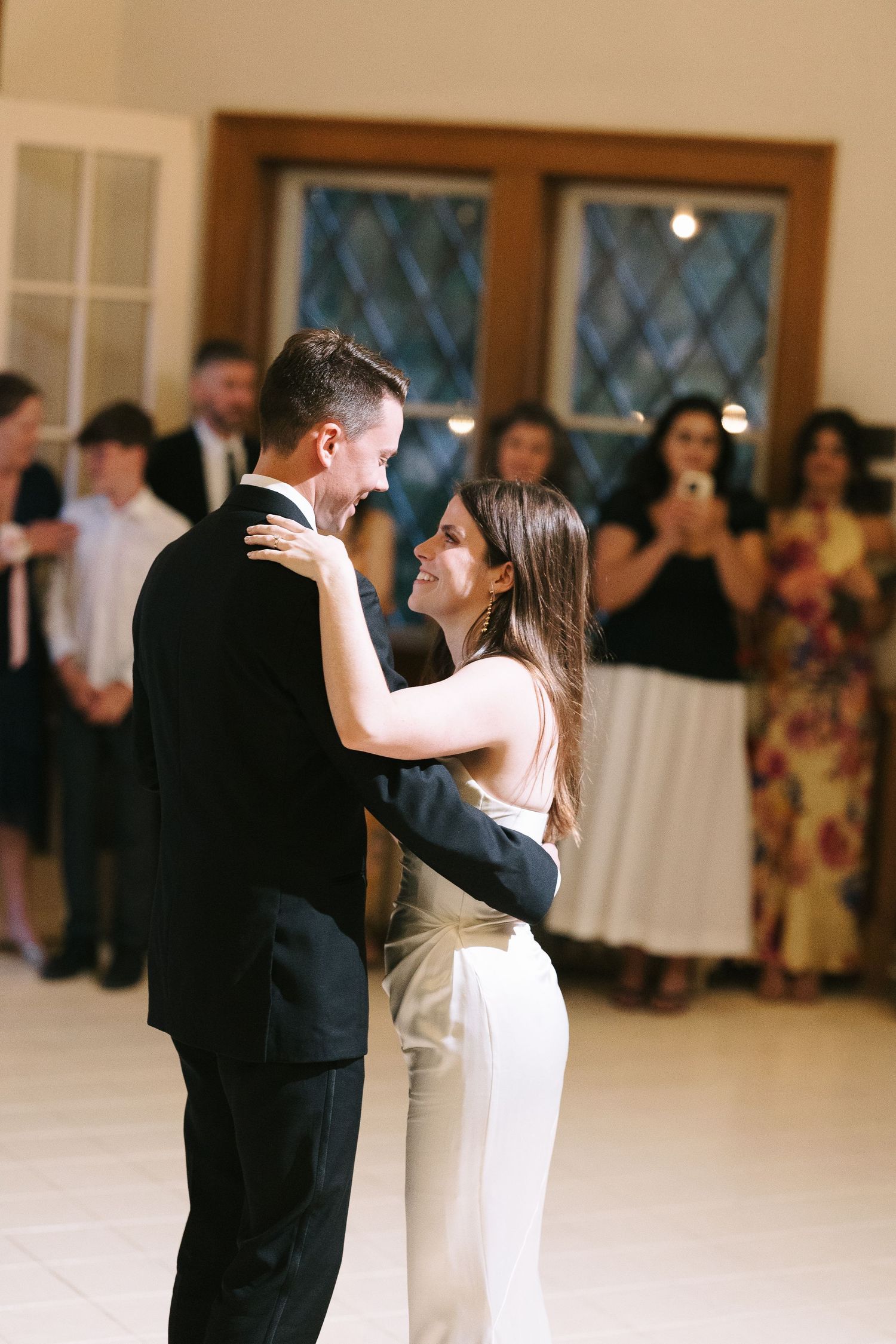 A joyful dance between two people at an indoor celebration.