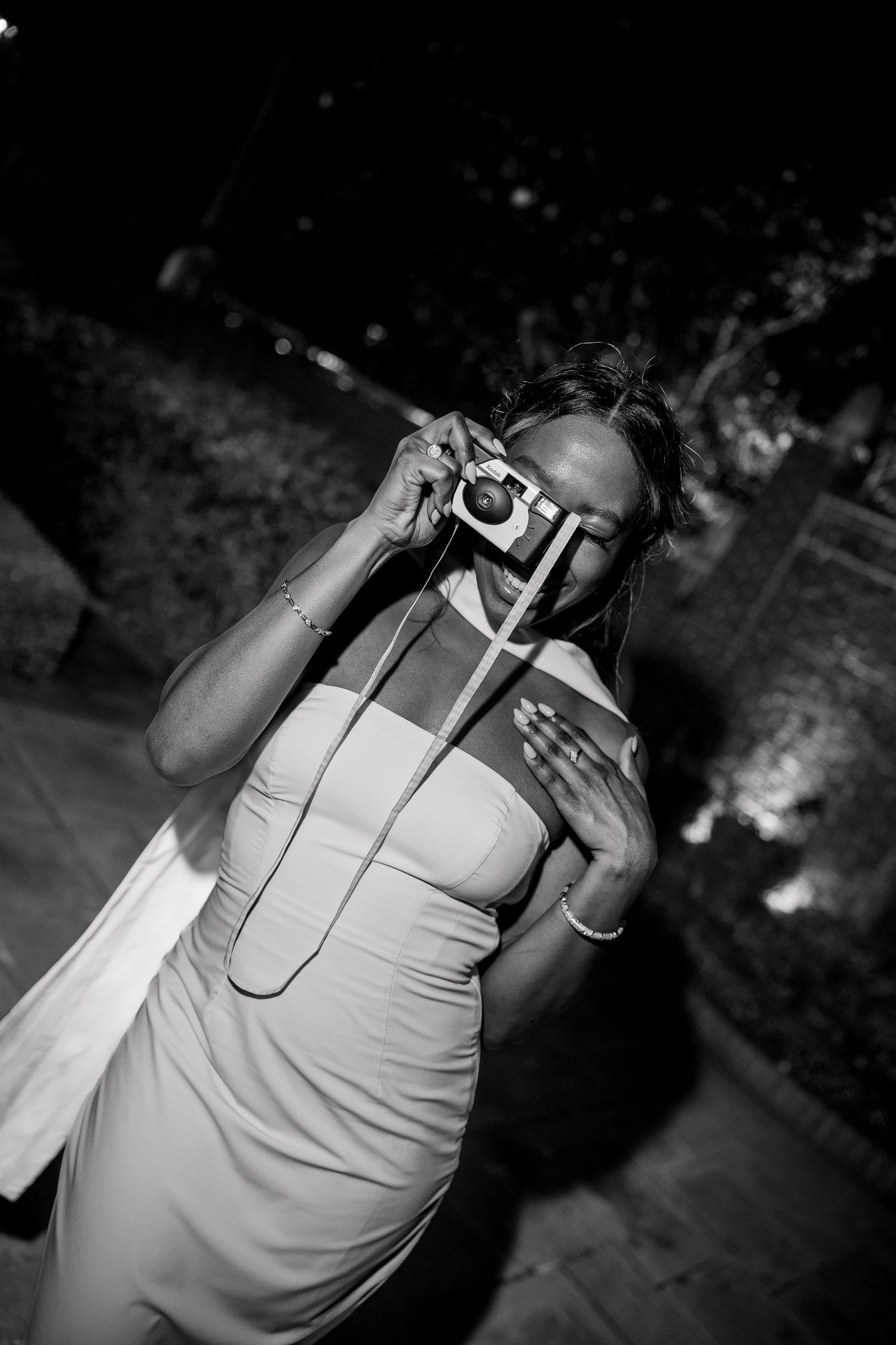 Person in white dress dancing outdoors at night.