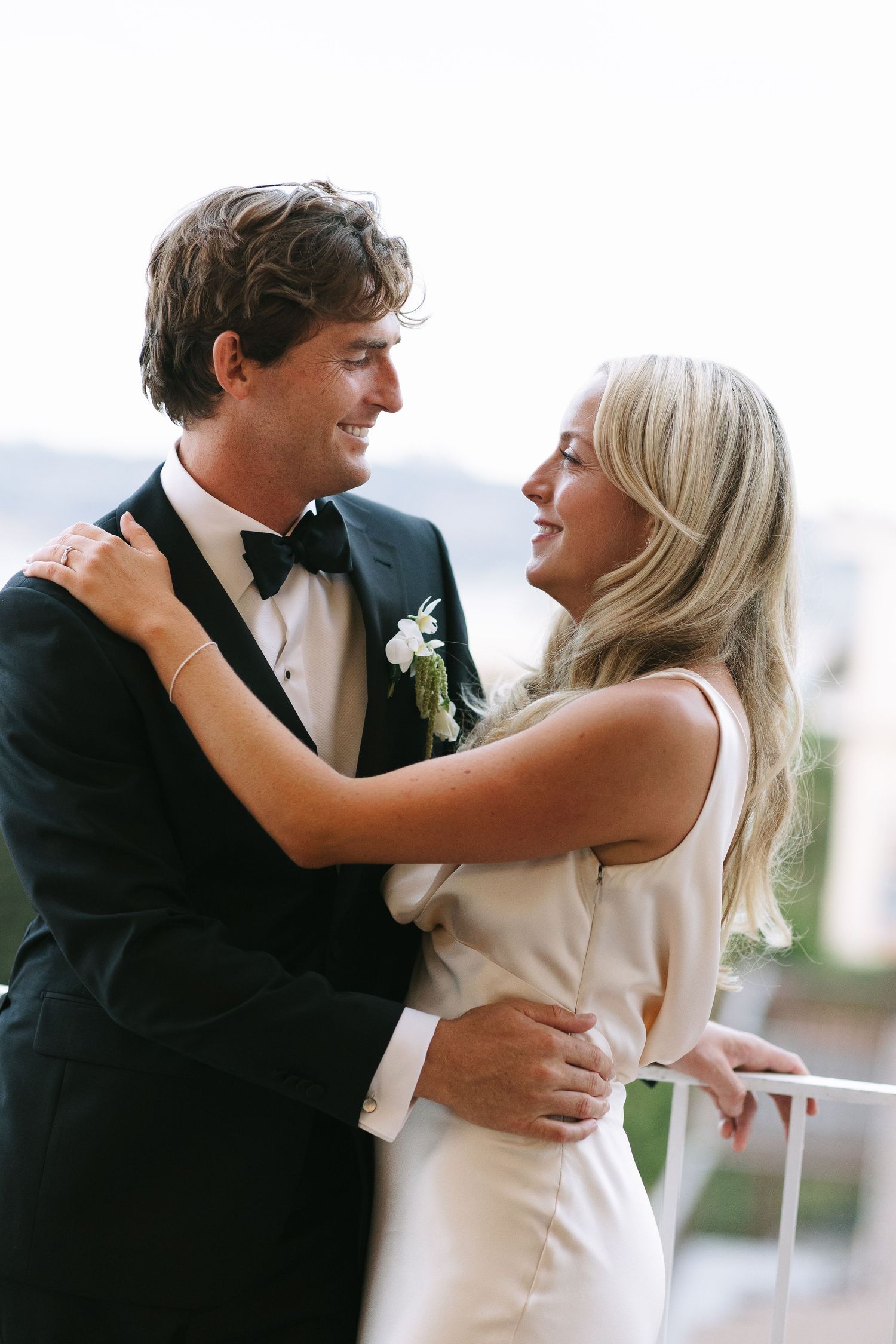 Happy newlyweds share joyful laughter while embracing on their wedding day.