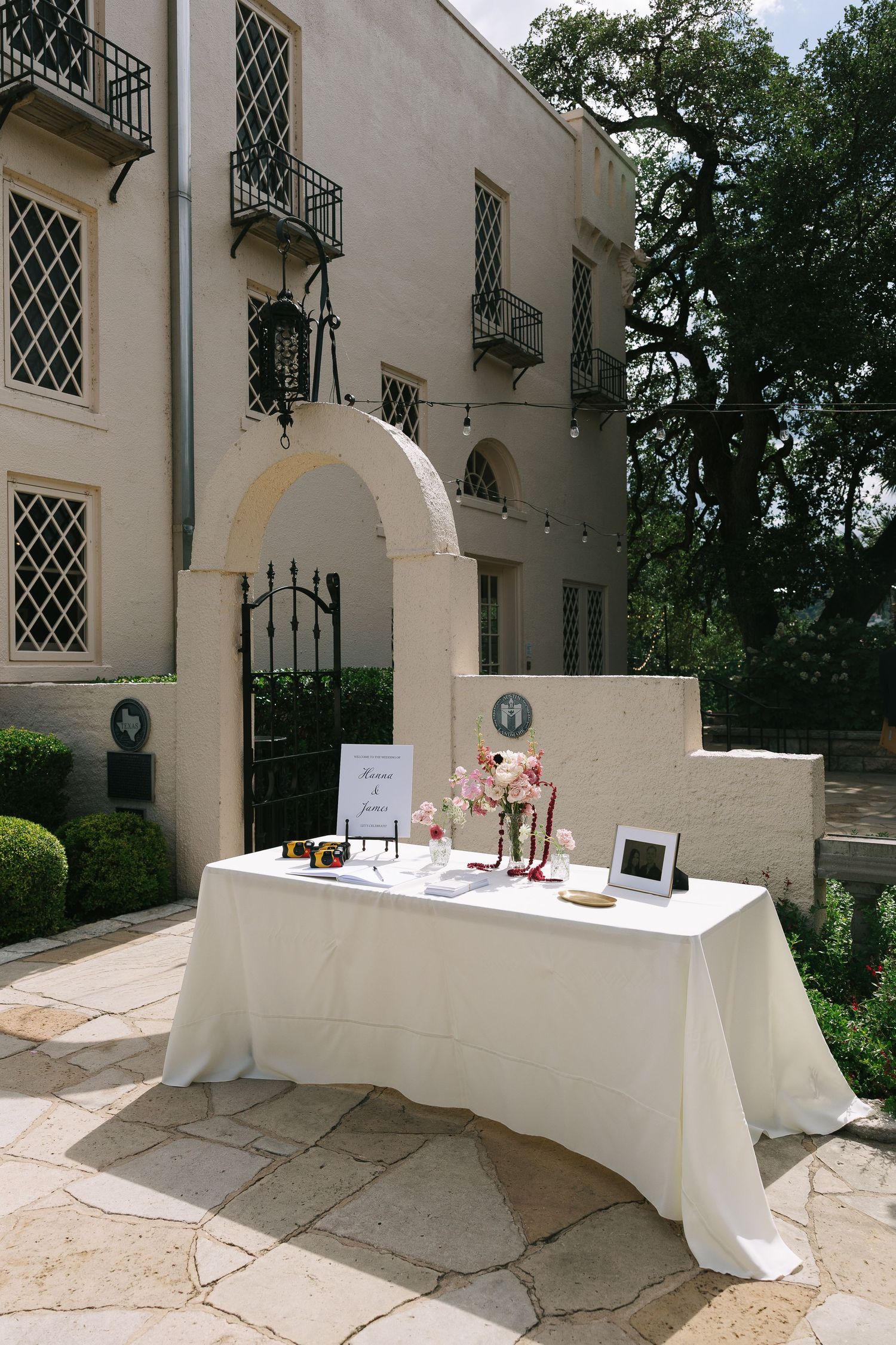 Elegant welcome table set up outside a stone building with arched entrance.