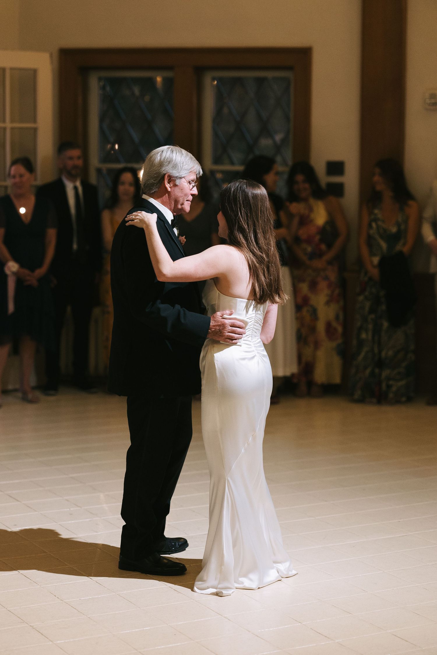 A special dance moment on a light colored dance floor at an indoor celebration.