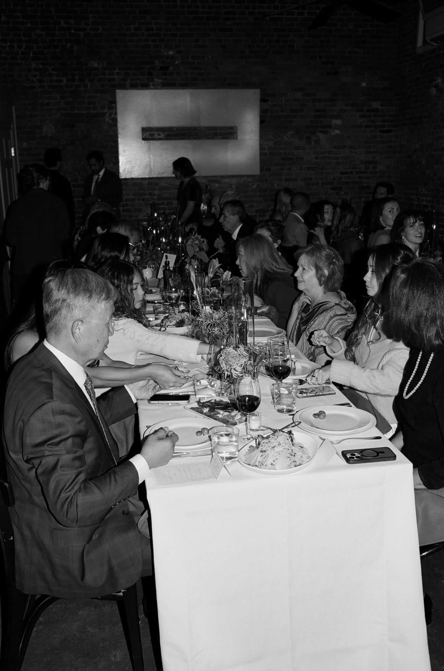 Vintage black and white photos showing people dining at formal tables with white tablecloths at an elegant event.