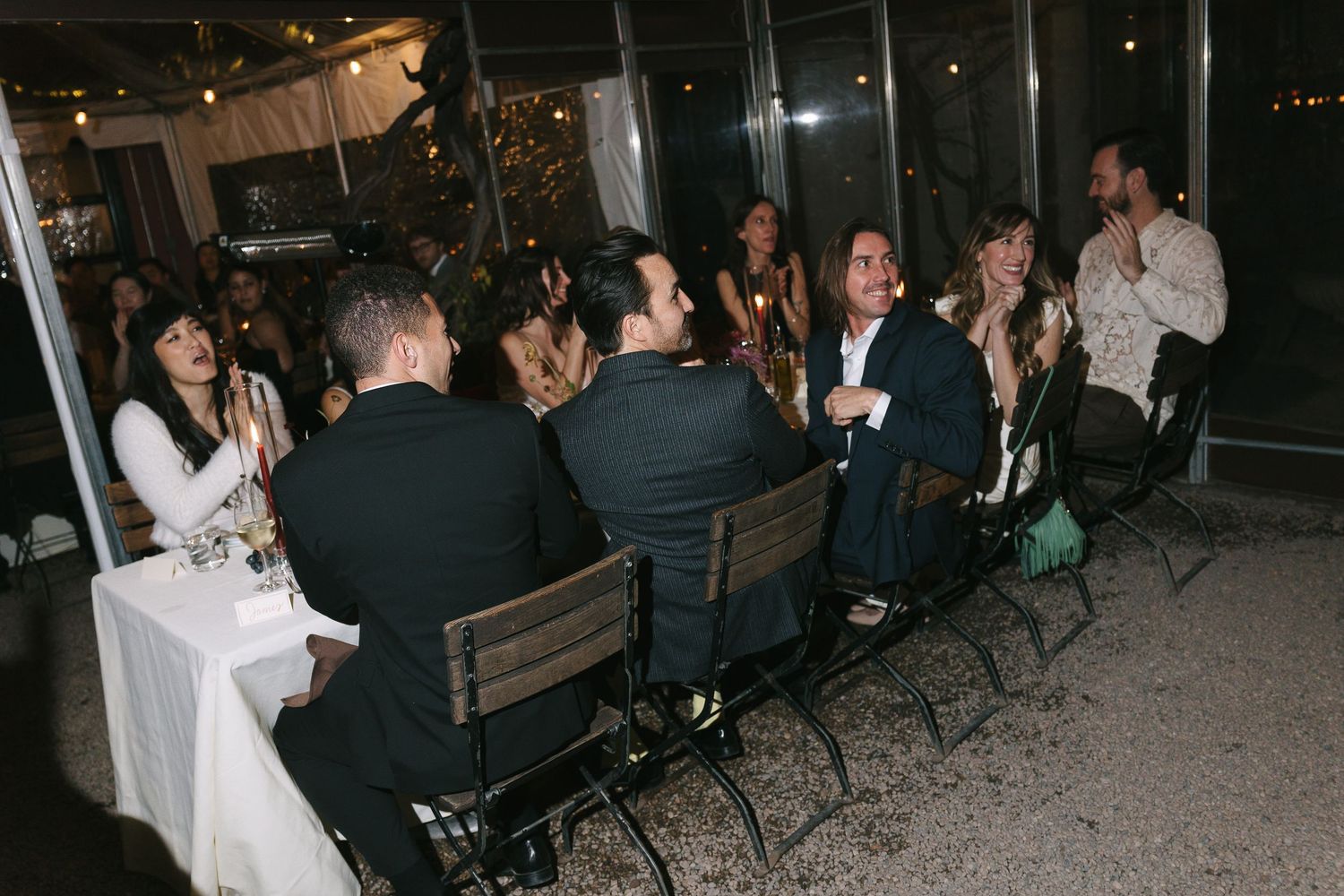 People socializing at tables during an evening event in a modern space.