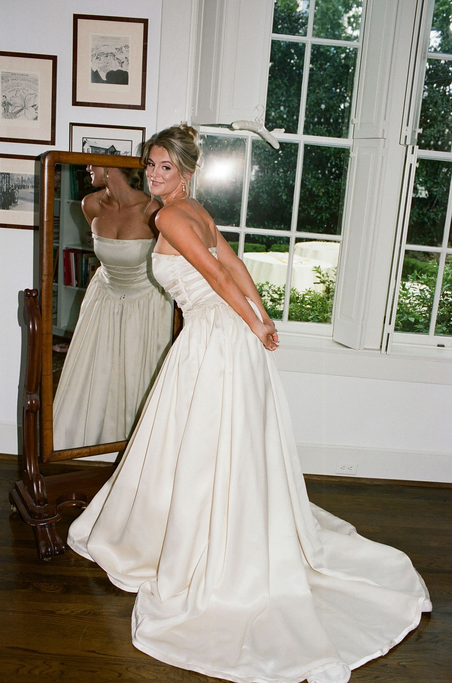 Person in elegant white ballgown spinning gracefully in a bright room with windows.