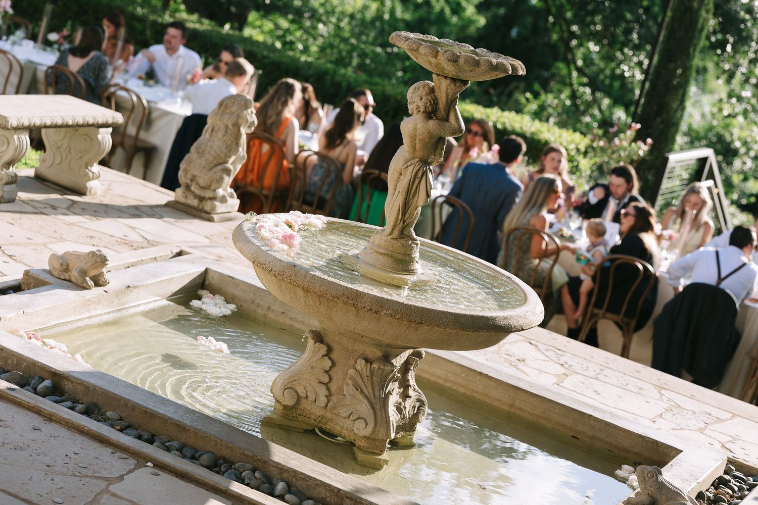 Decorative stone water fountain with ornate carvings in an outdoor setting.