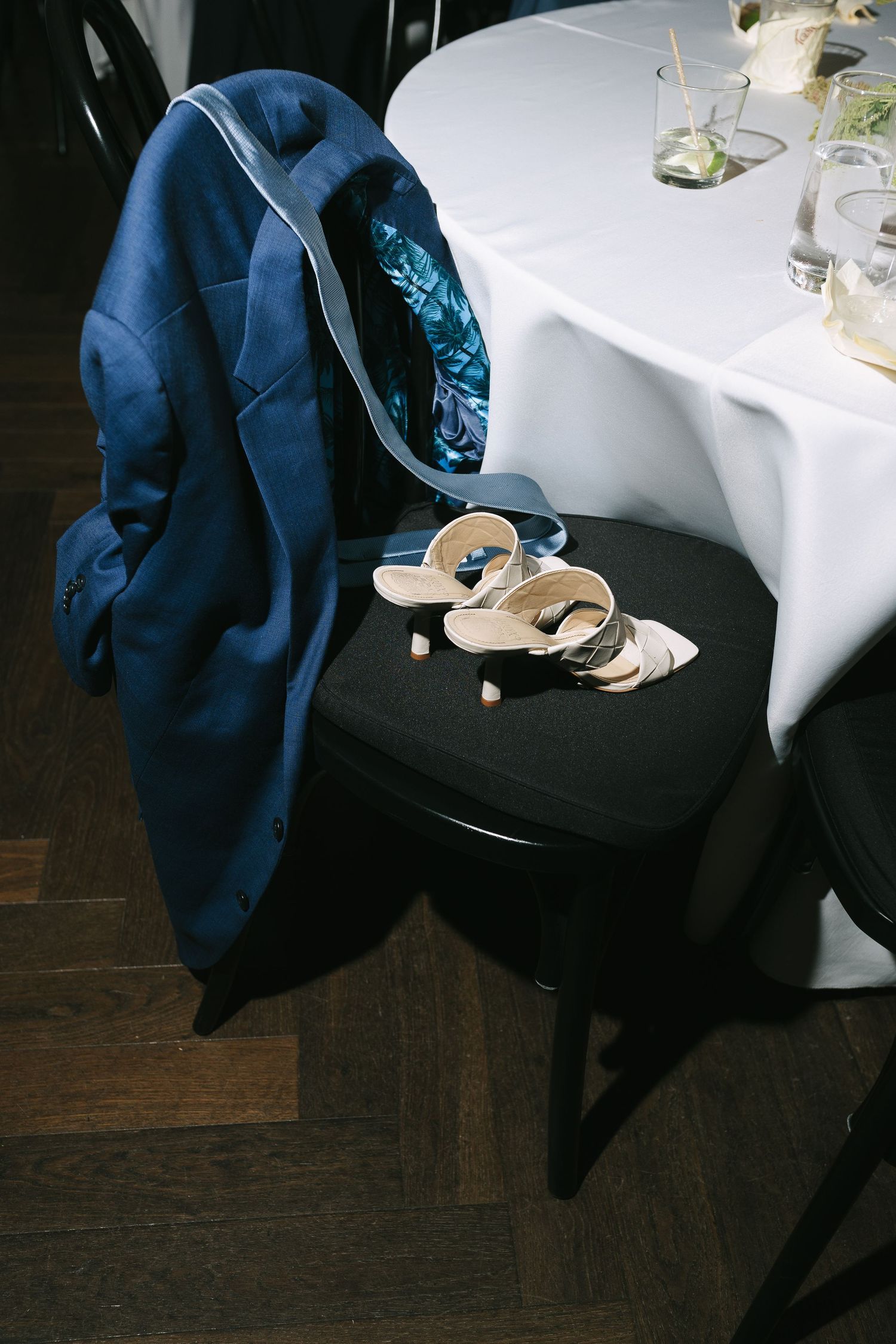High heel shoes and formal attire visible near a white tablecloth at an elegant event.