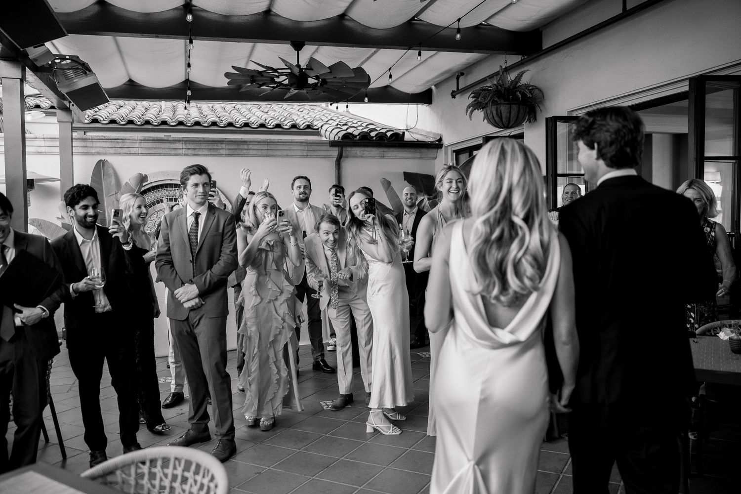 Wedding reception guests dancing and celebrating in an elegant indoor venue.