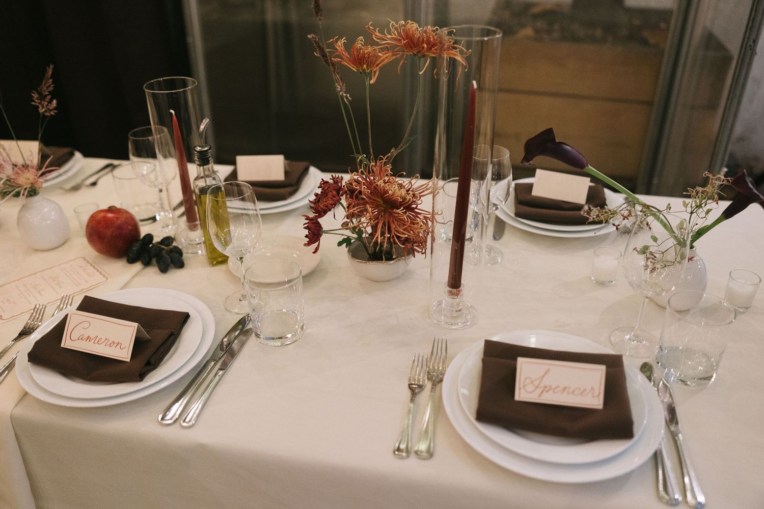Formal dining table with white tablecloth, place settings, and delicate floral centerpieces.