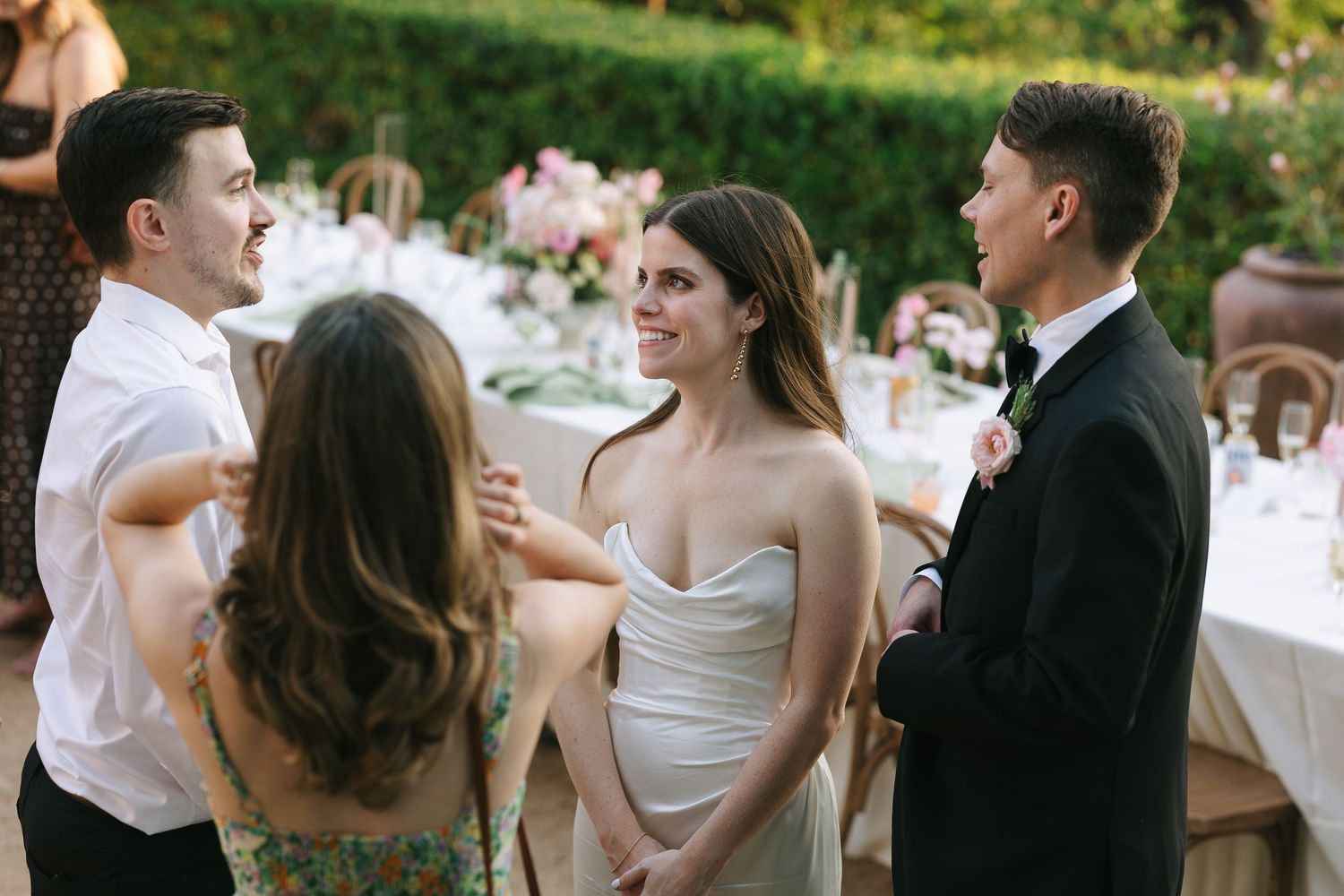 Guests mingling at an elegant outdoor reception with formal attire.