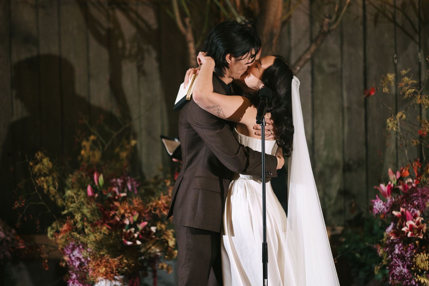 A couple shares an intimate moment during their nighttime garden wedding ceremony.