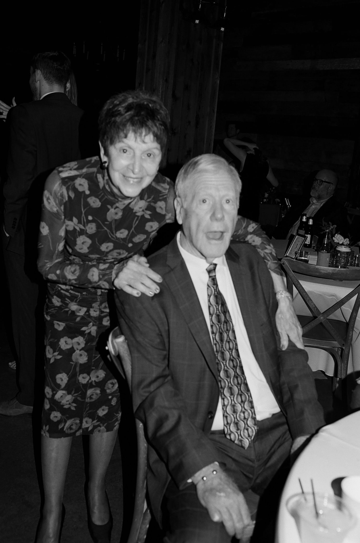A black and white photo series showing people in formal attire at what appears to be an evening social event.