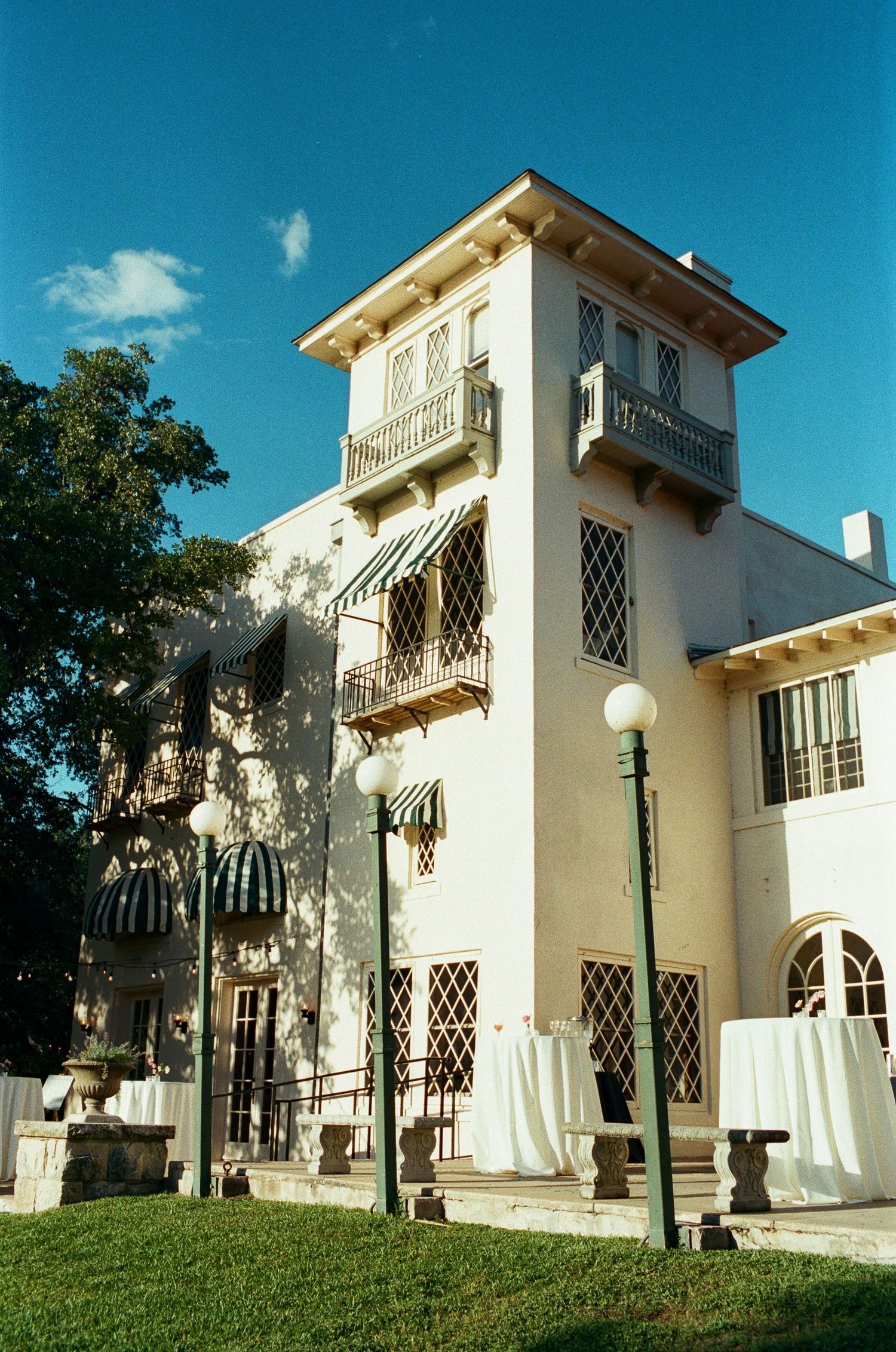 Exterior view of an elegant white Mediterranean-style villa with arched windows and balconies.