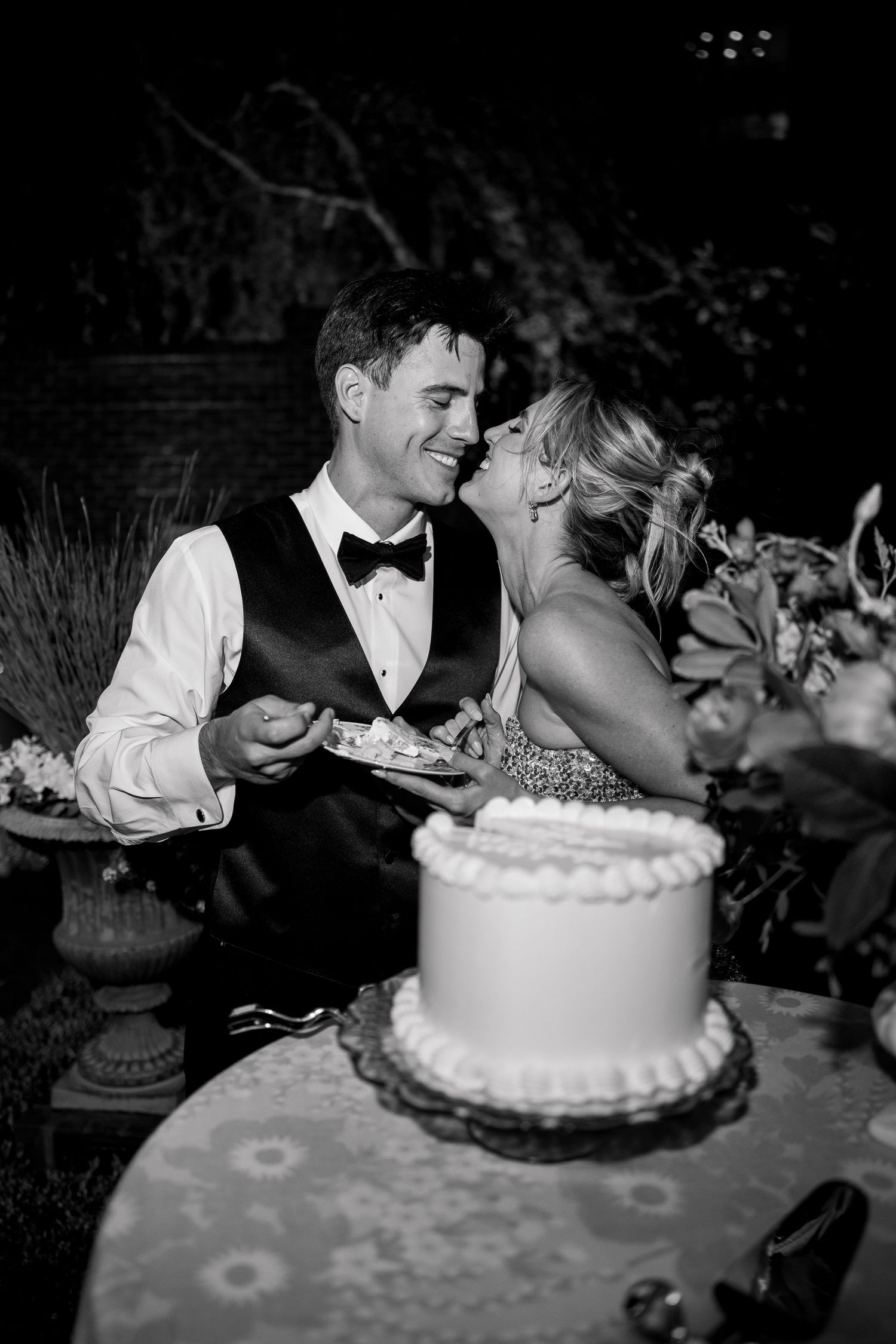 Wedding couple sharing playful moment while cutting their cake at reception.