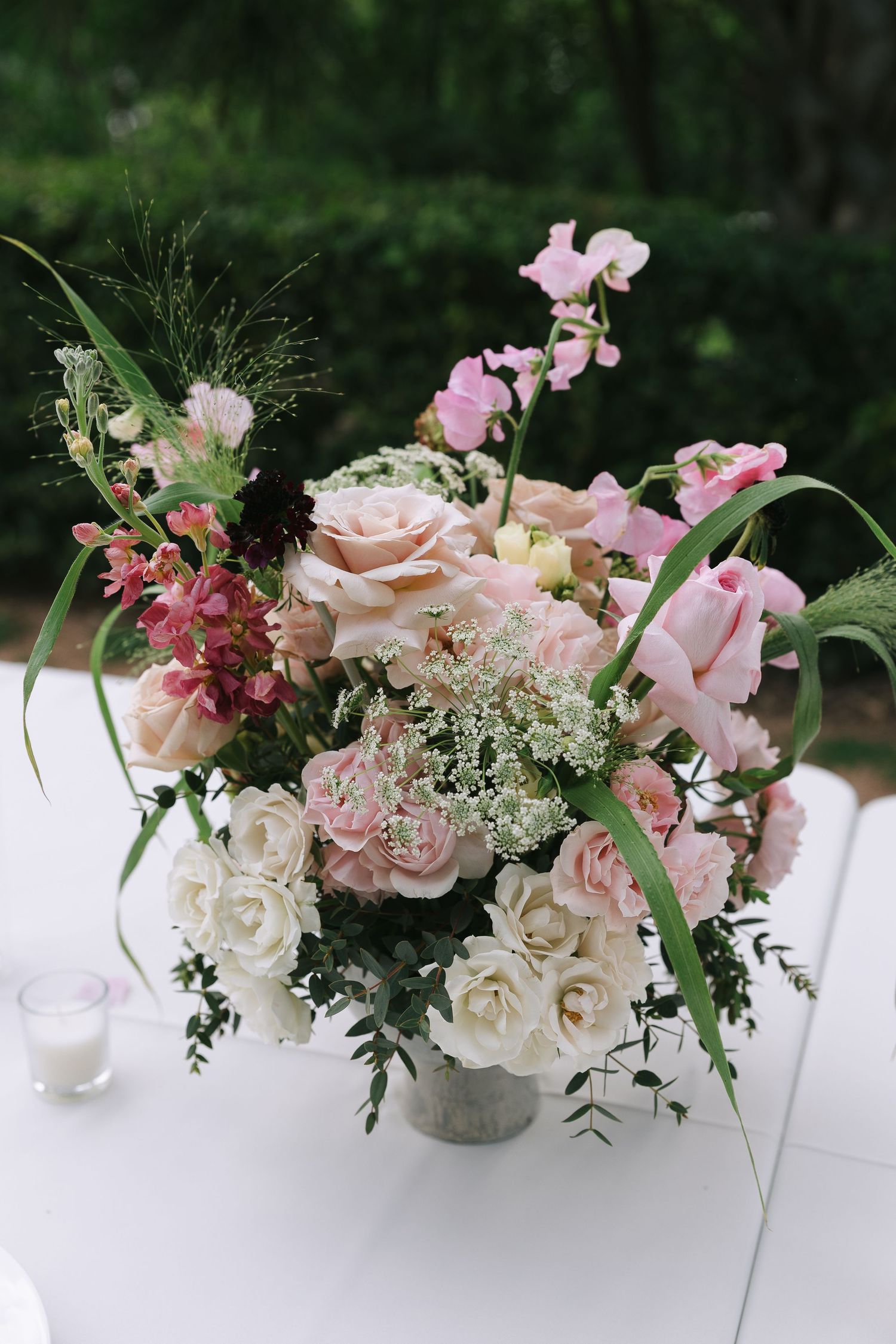 Romantic pink and white flower arrangement with roses and delicate greenery.