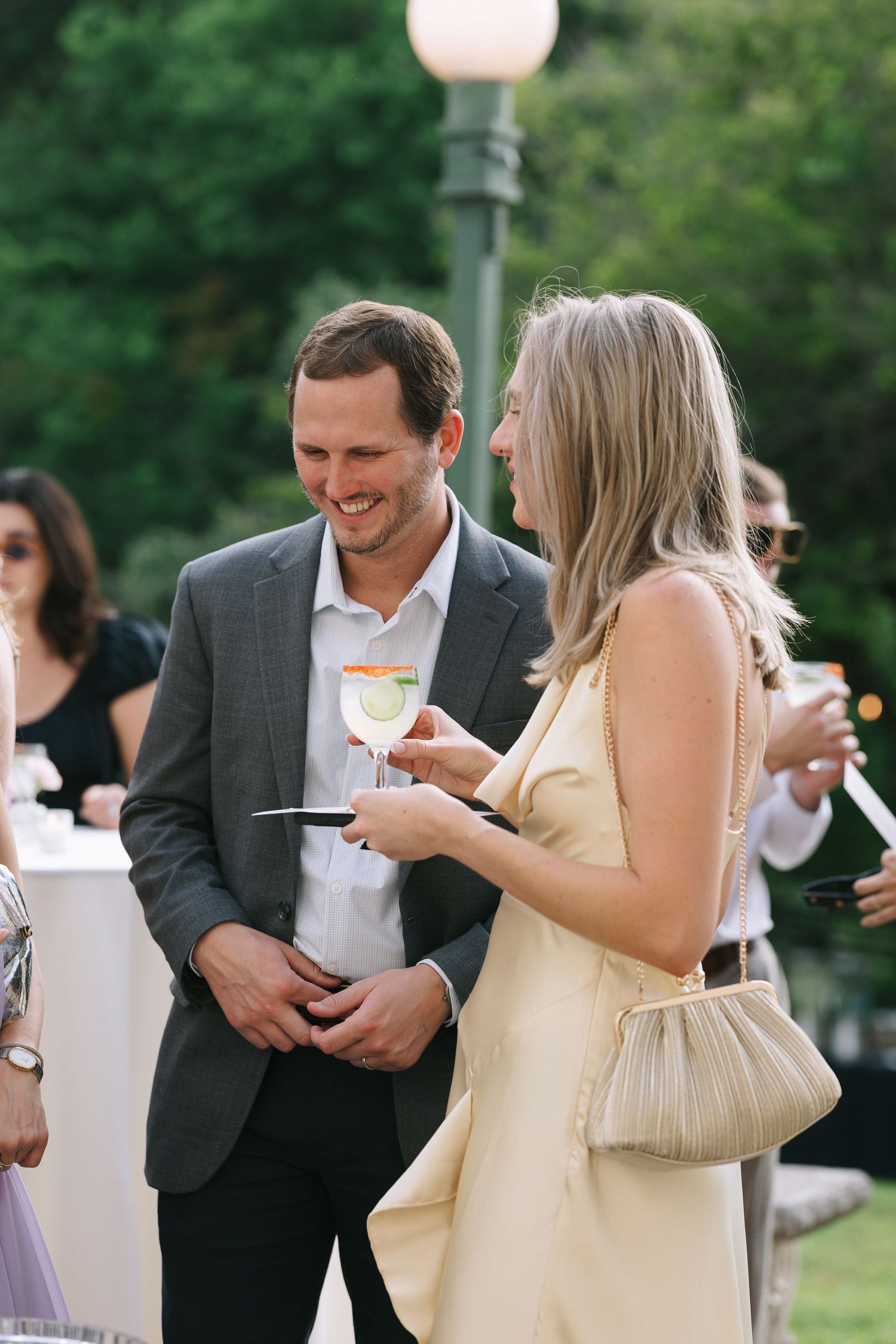 Wedding guests mingle and socialize at an outdoor cocktail reception.