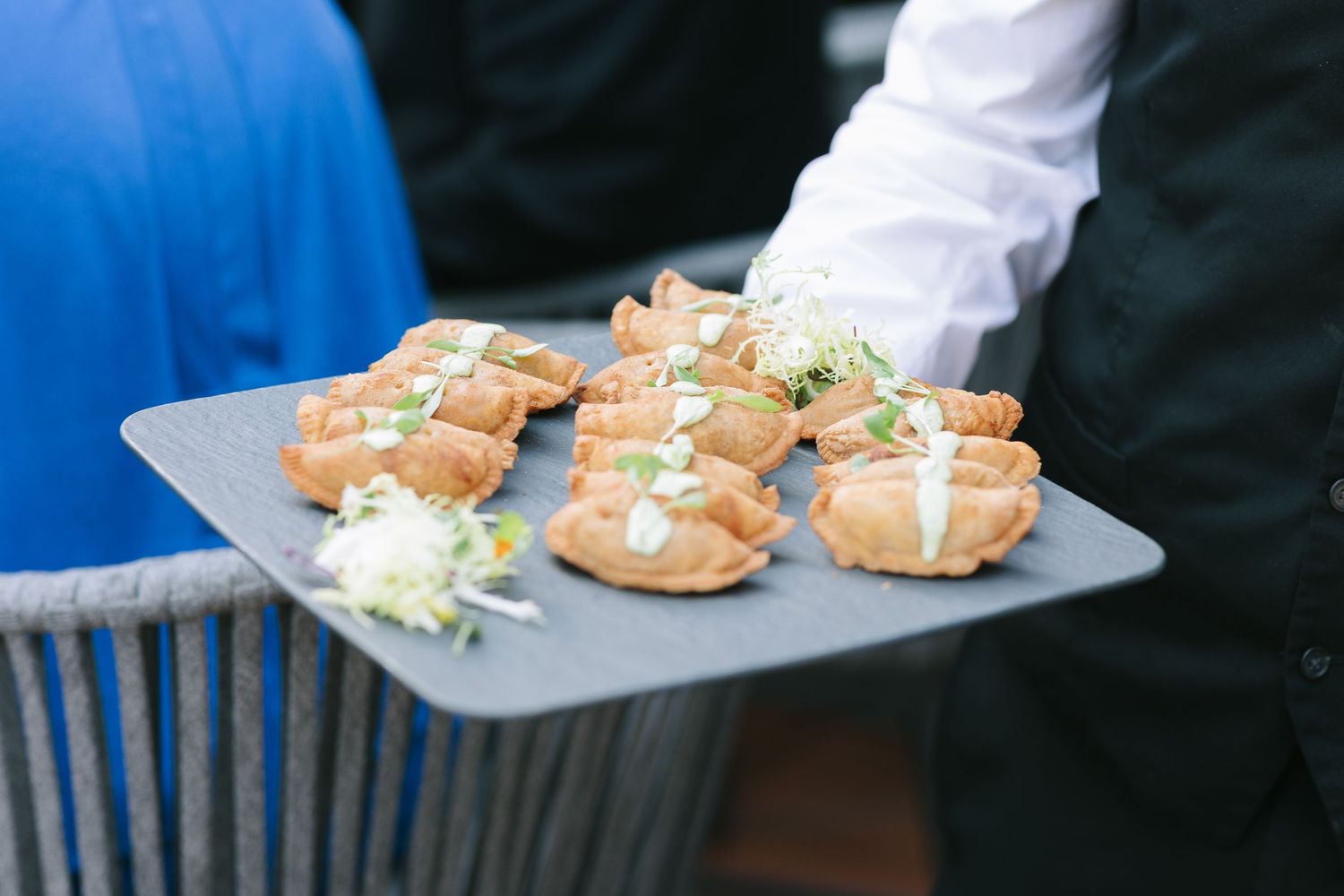 Small appetizers and hors d'oeuvres being served on white plates at an elegant event.