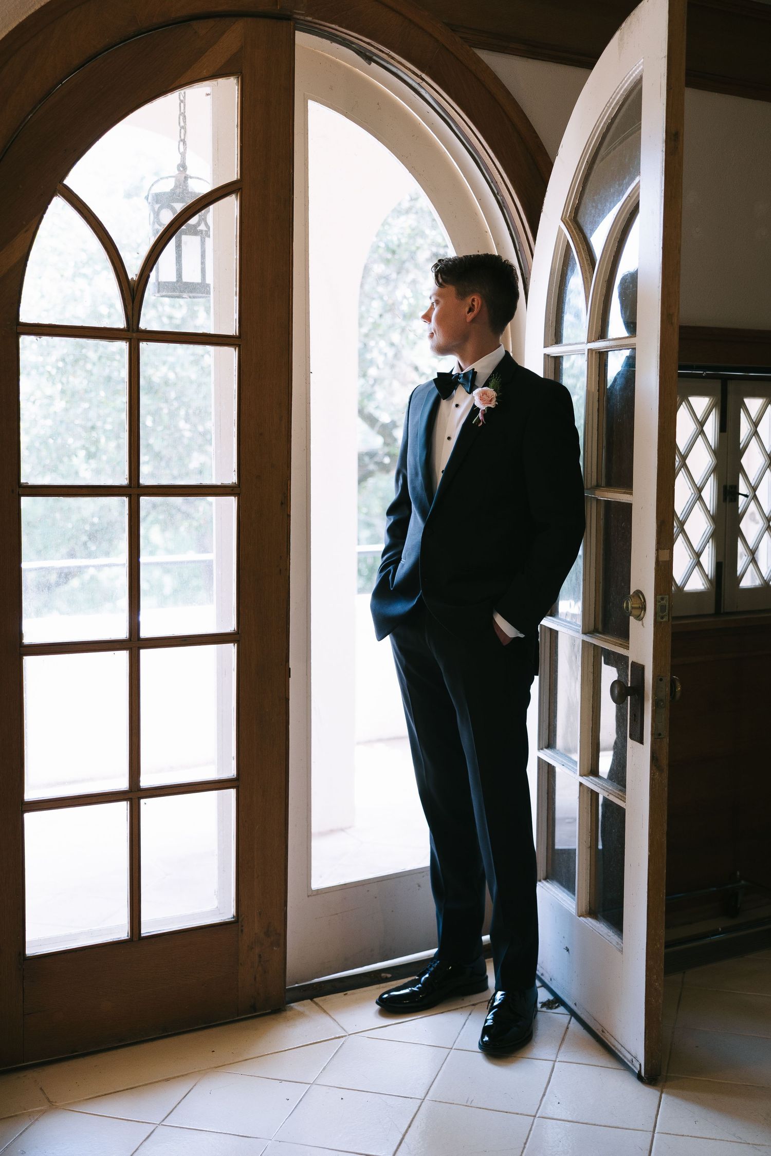 Elegant silhouette against arched doorway in formal attire.