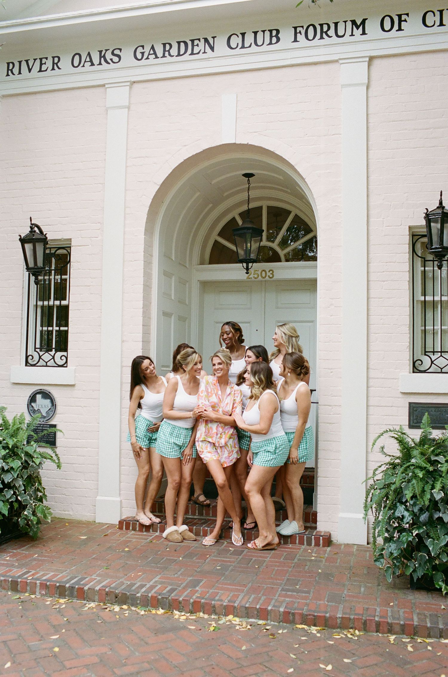 Wedding party gathers at River Oaks Garden Club Forum entrance for celebratory photos.