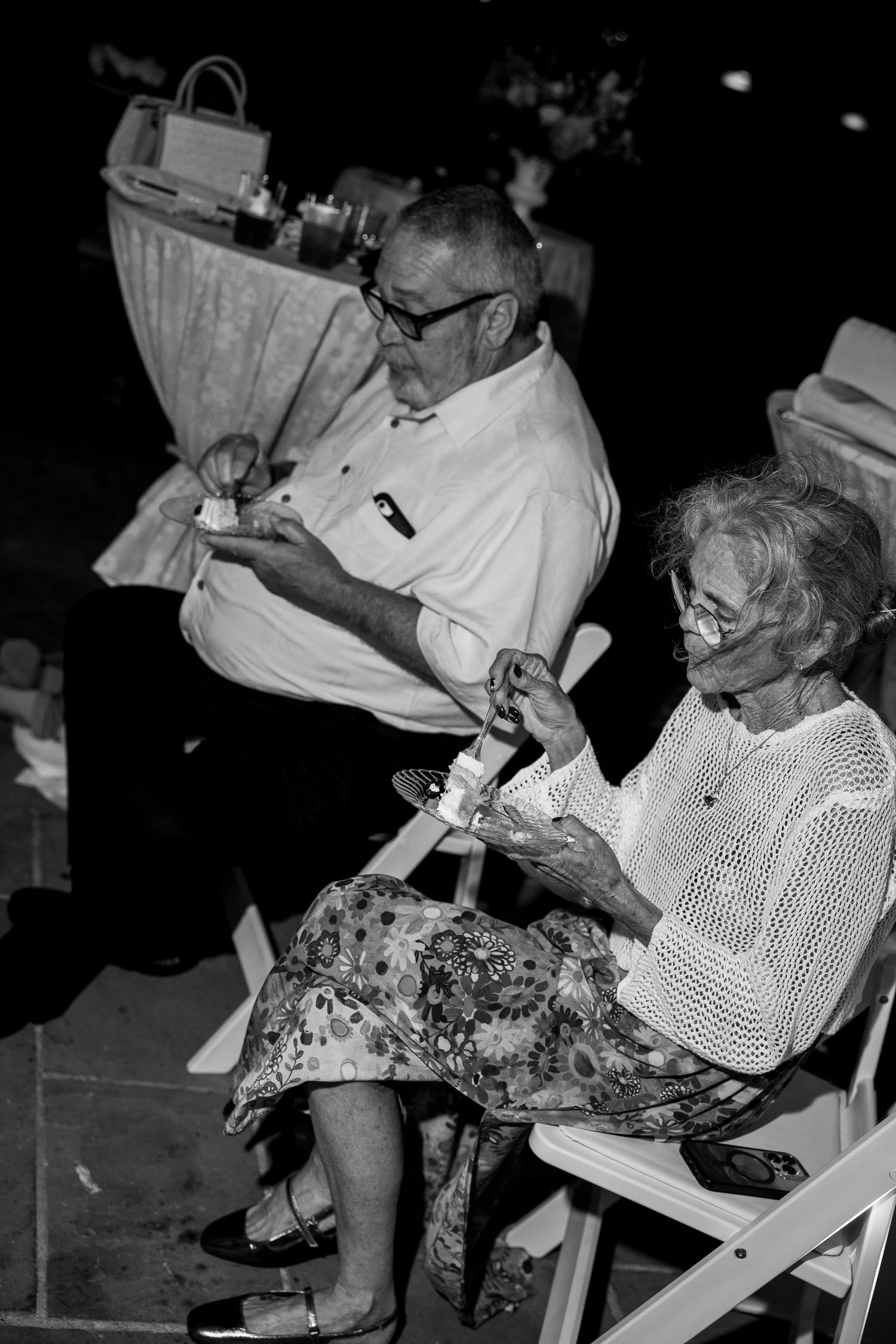 Black and white photograph of guests seated in chairs at an outdoor event.