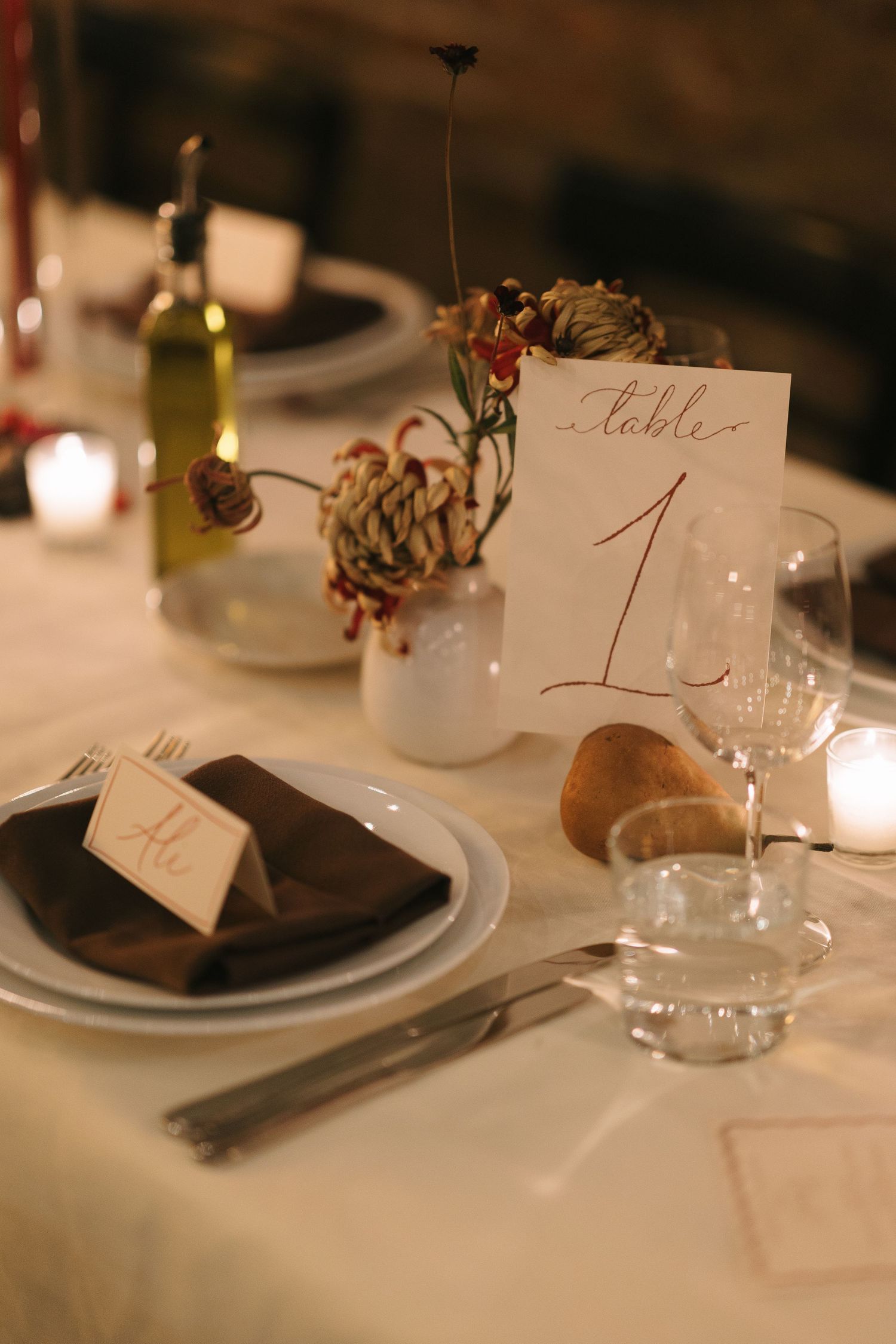 Close-up of wedding reception table settings with table numbers and place cards.
